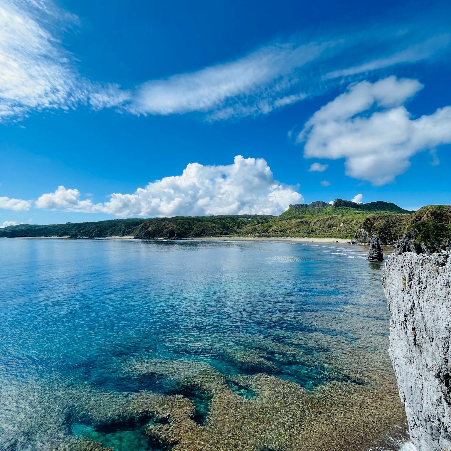 Garis pantai yang indah dengan langit biru cerah dan air tenang