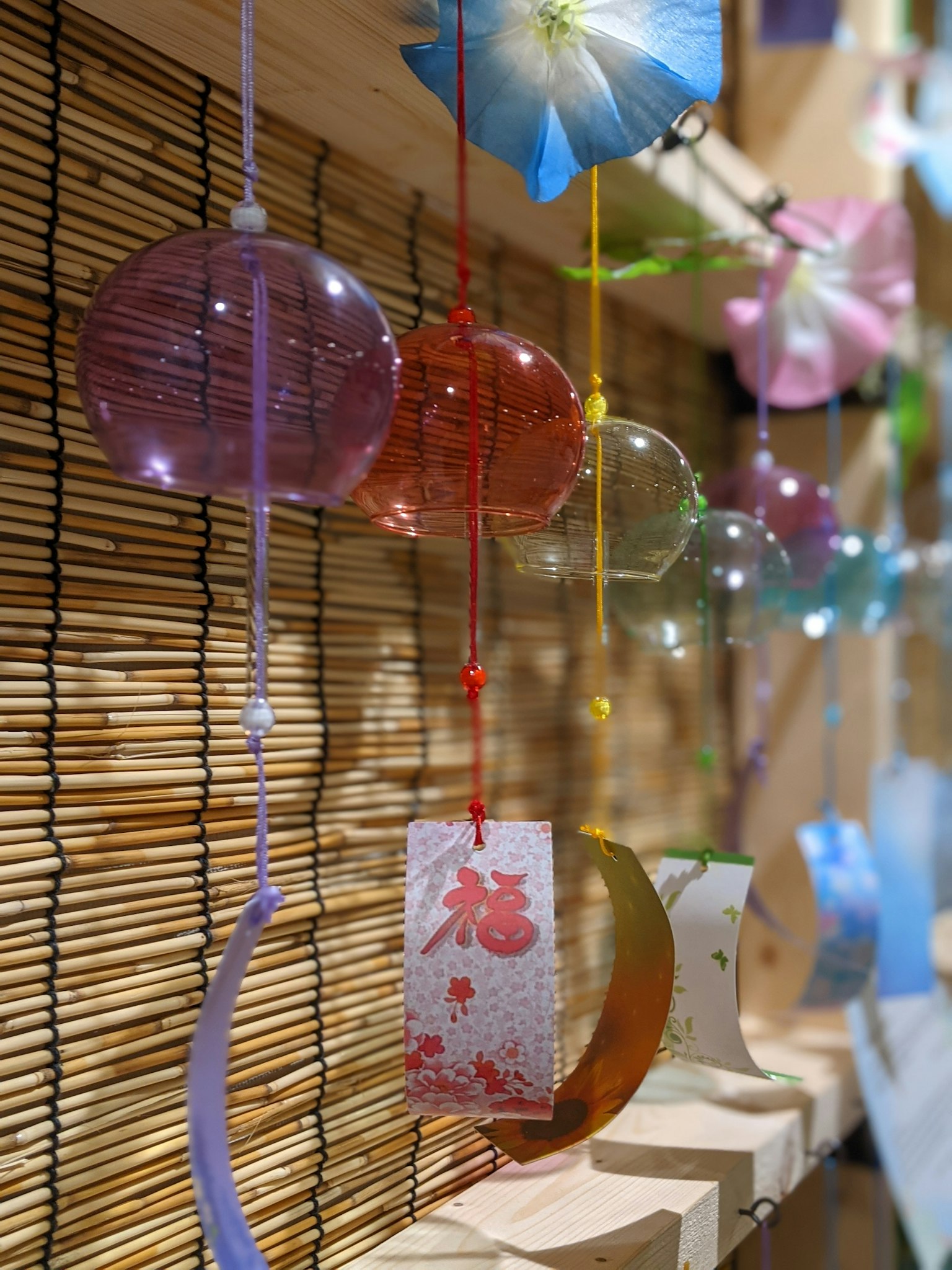 Campanillas coloridas colgando con elementos decorativos y papel washi