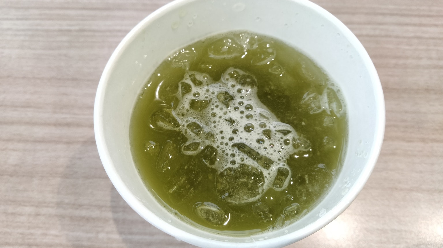 Boisson verte mousseuse dans une tasse blanche