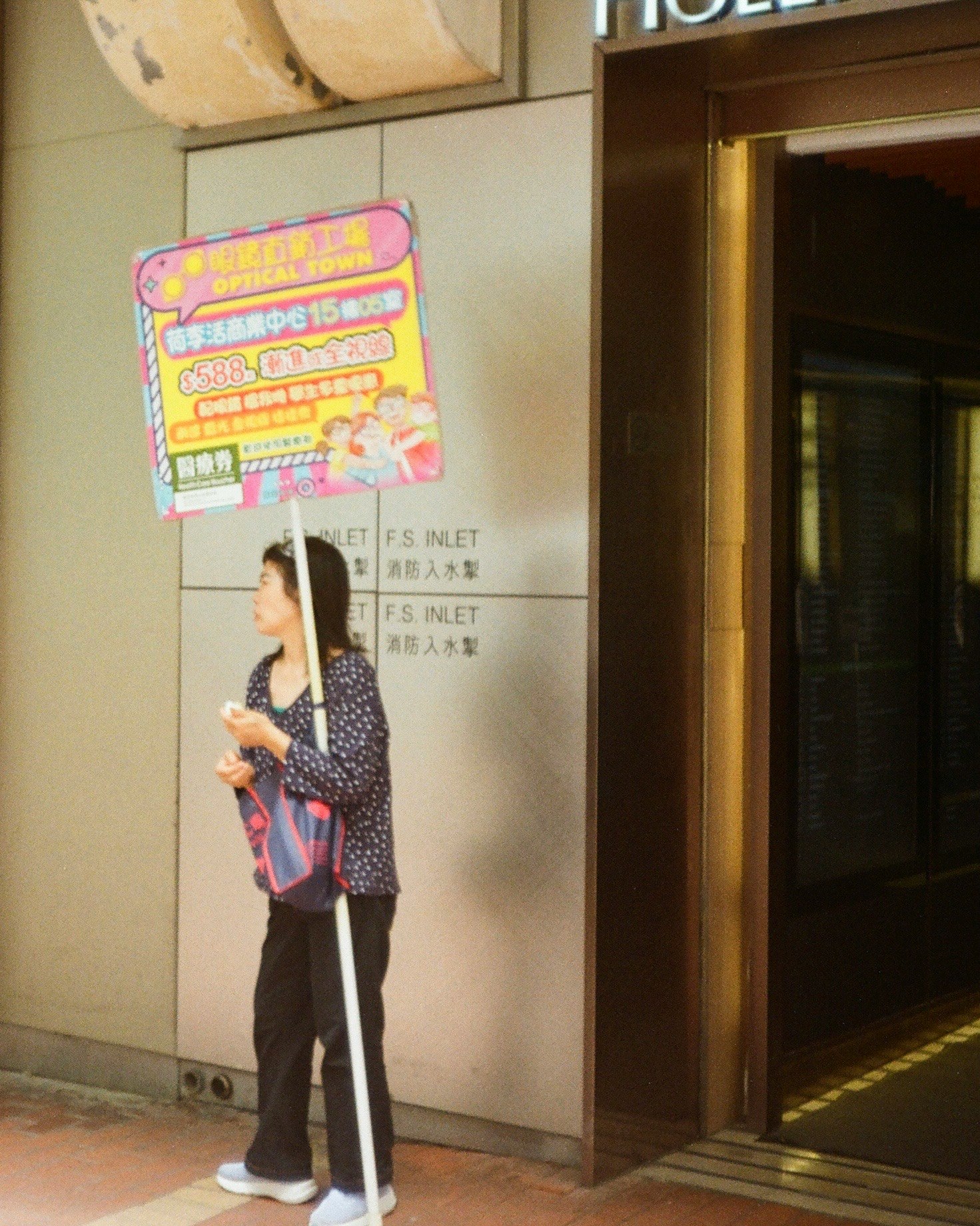 店先の看板前で立つ親子の姿