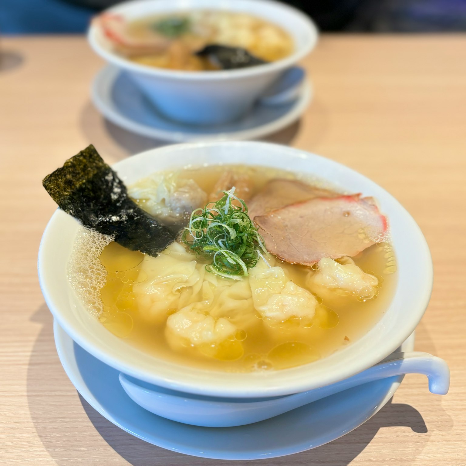 一碗清汤拉面，配有切片猪肉和海苔