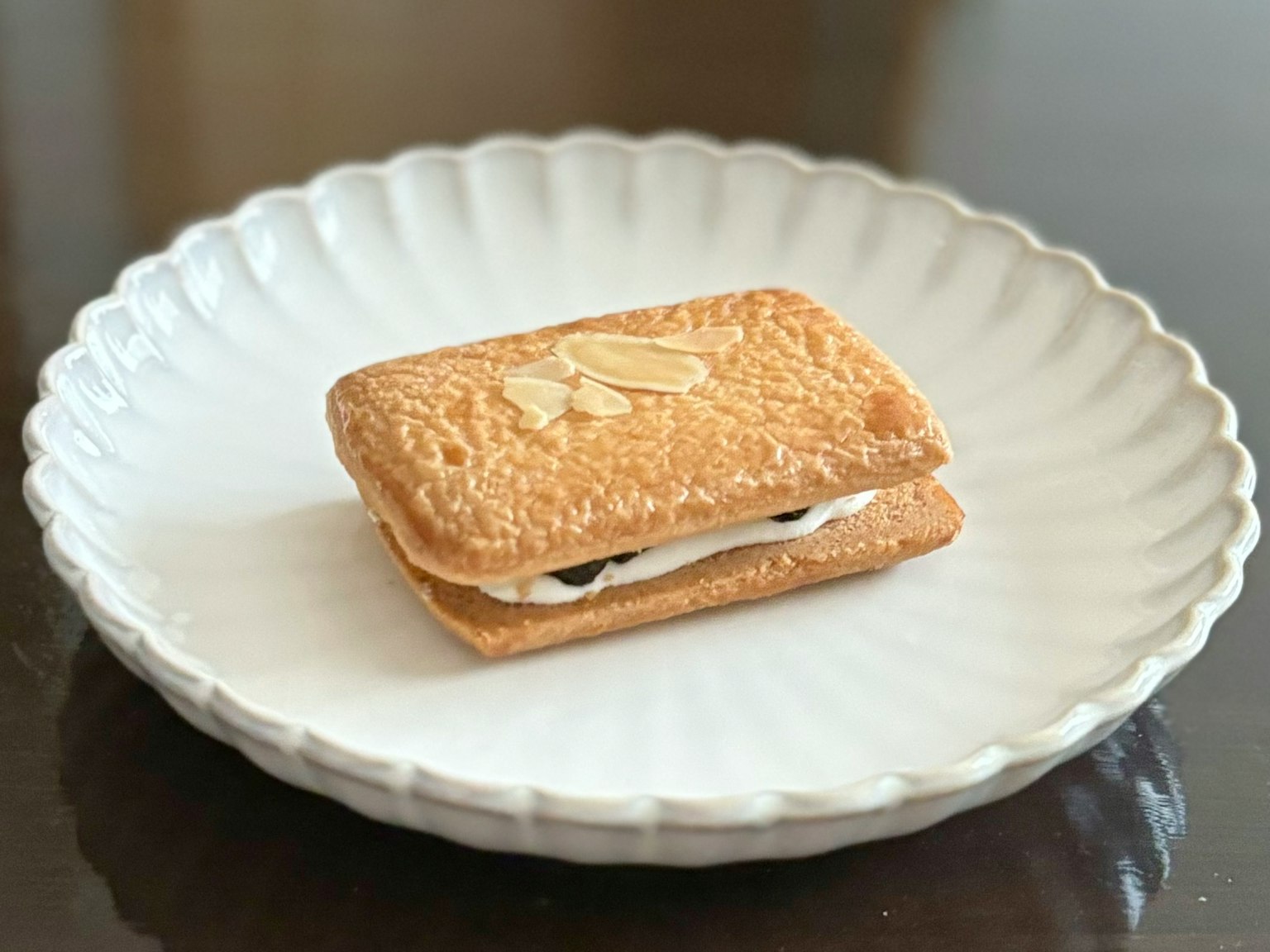 A two-layer cookie with cream on a white plate