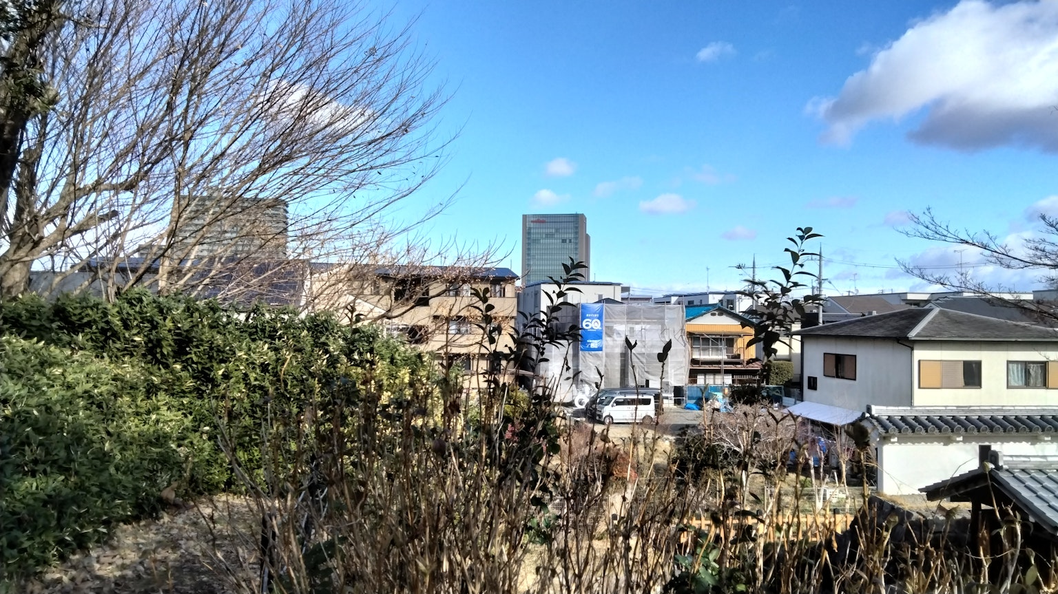 Vue de bâtiments sous un ciel bleu clair avec de la verdure et des zones résidentielles