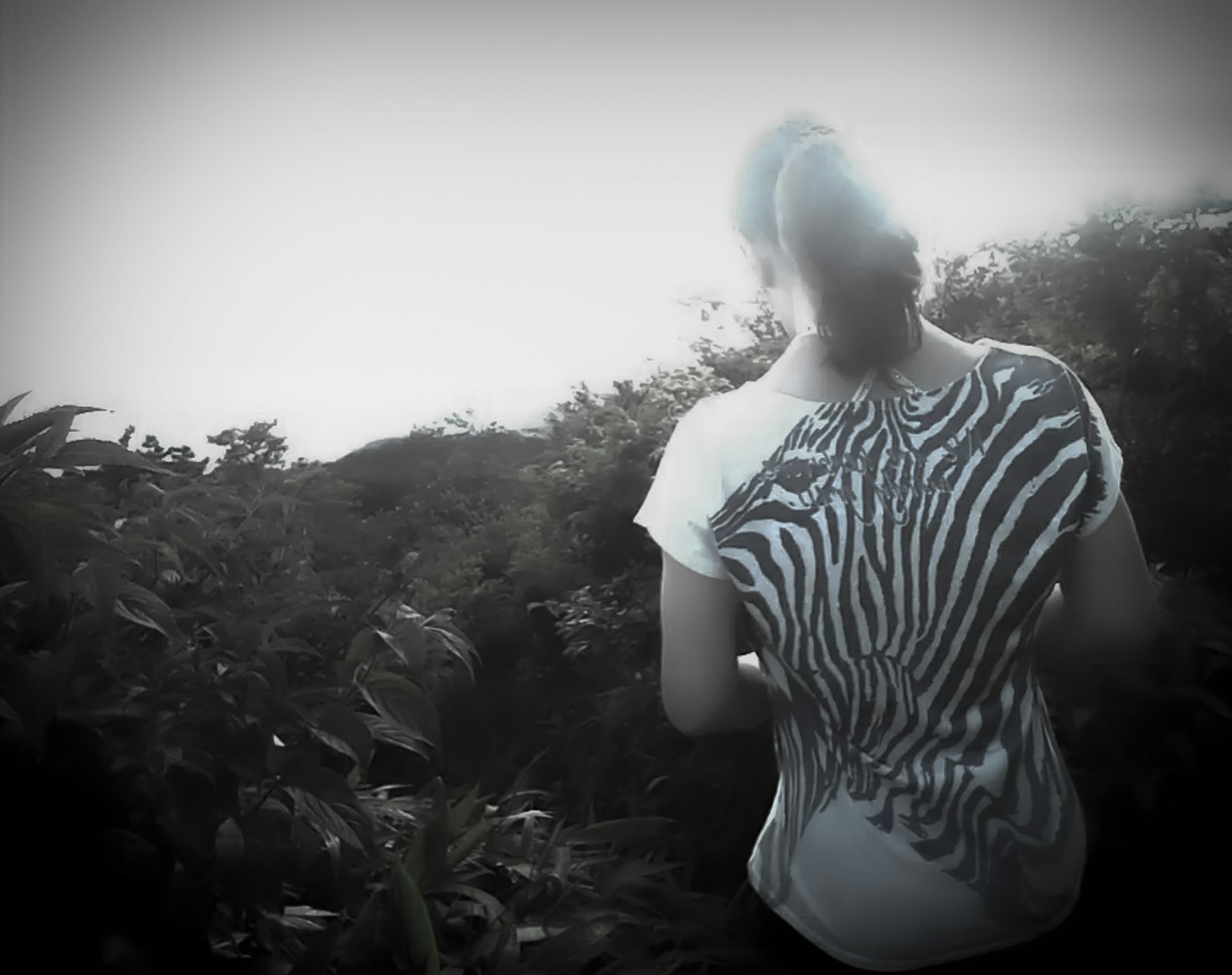 Mujer con camiseta de estampado de cebra caminando en un bosque