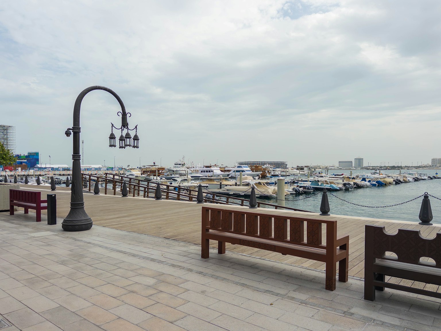 Vista escénica de un paseo marítimo con bancos y una farola