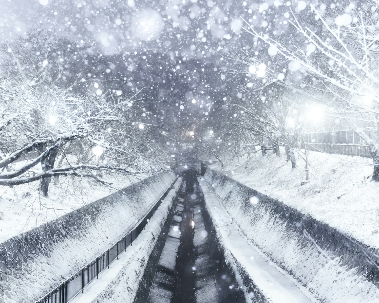 Schneebedeckte Landschaft mit fallendem Schnee und einem Fluss