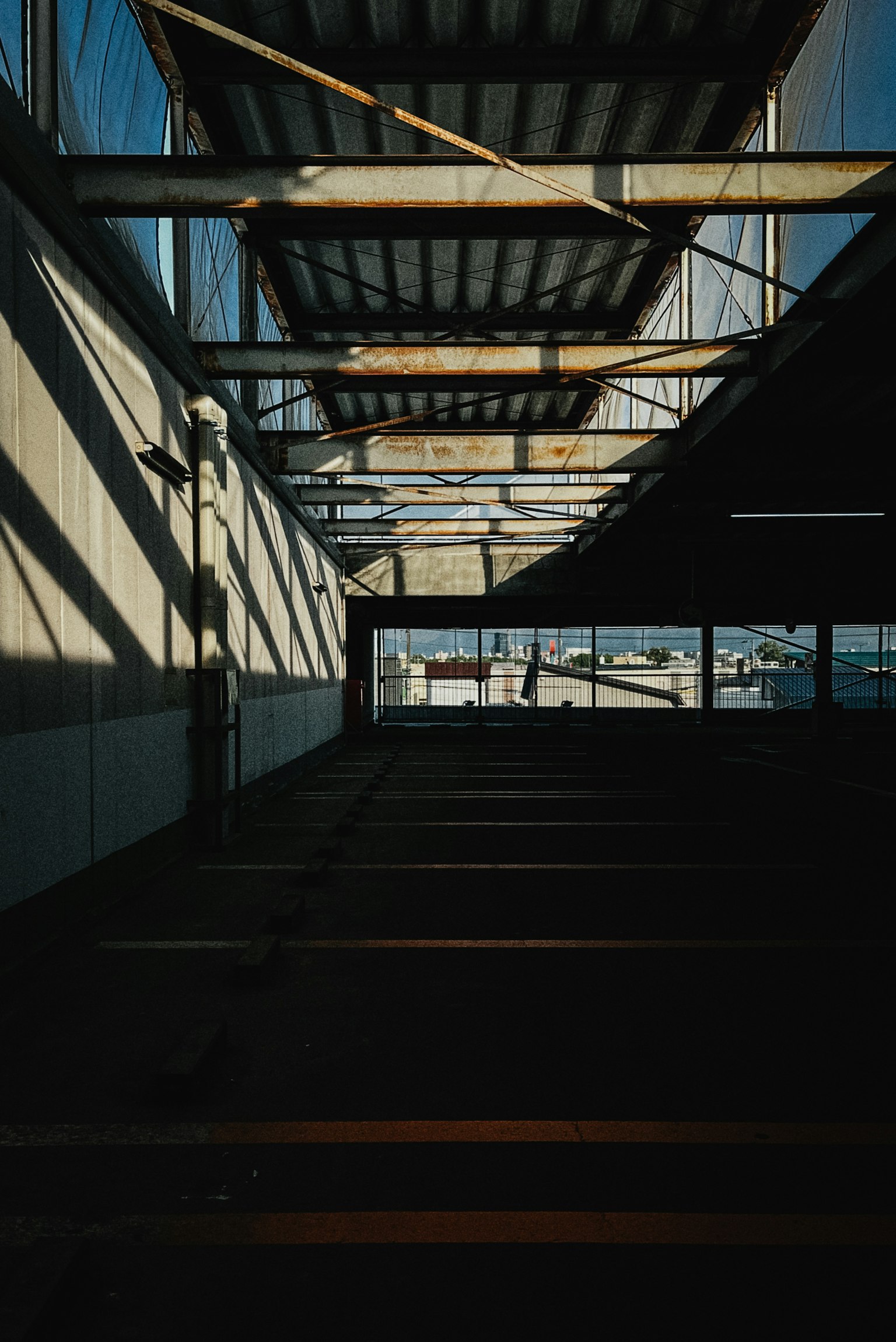 Eine Innenansicht, die das Zusammenspiel von Schatten und Licht in einer industriellen Umgebung zeigt