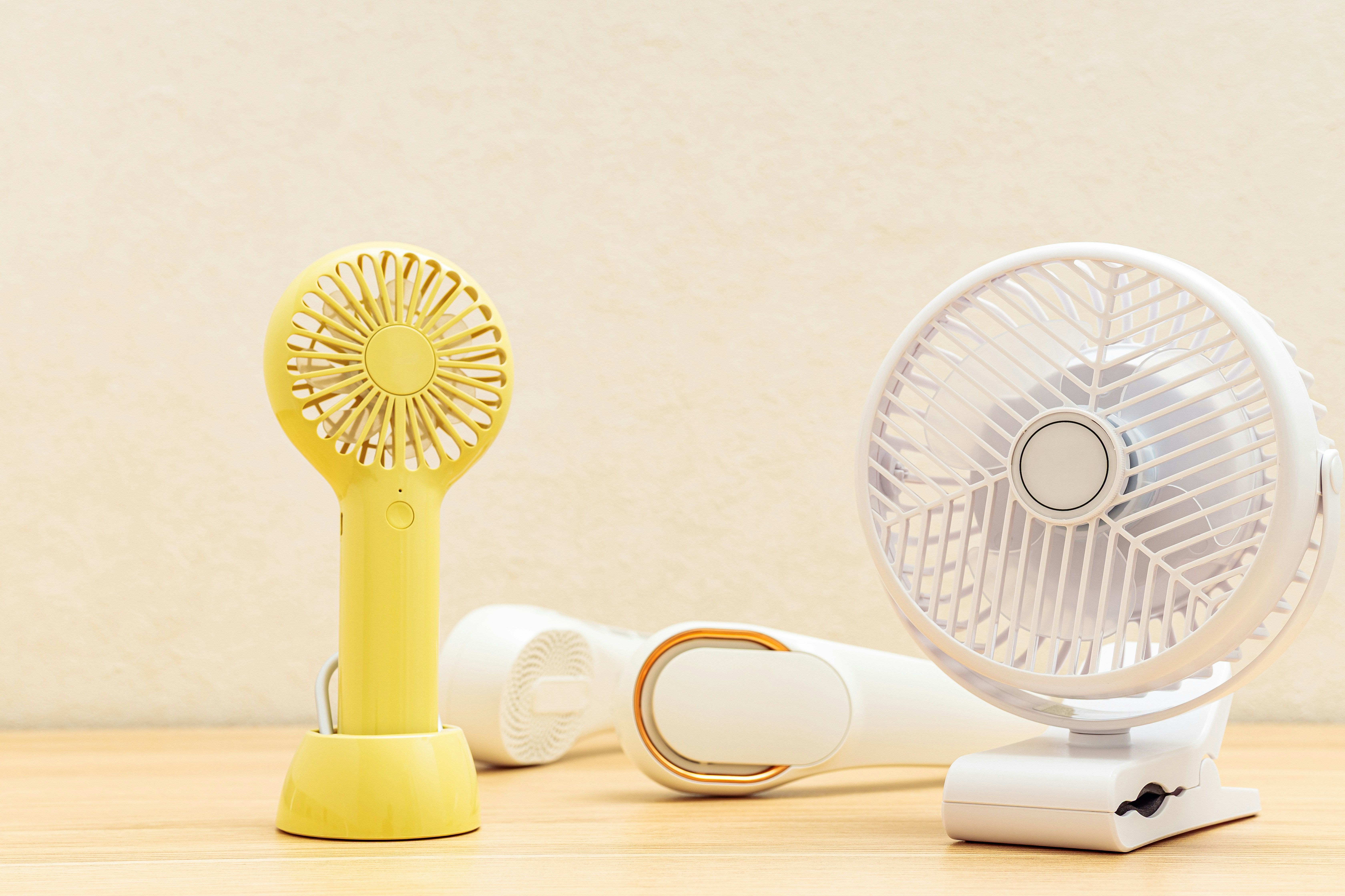 卓上に並ぶ扇風機とモバイルバッテリーのある夏の家電