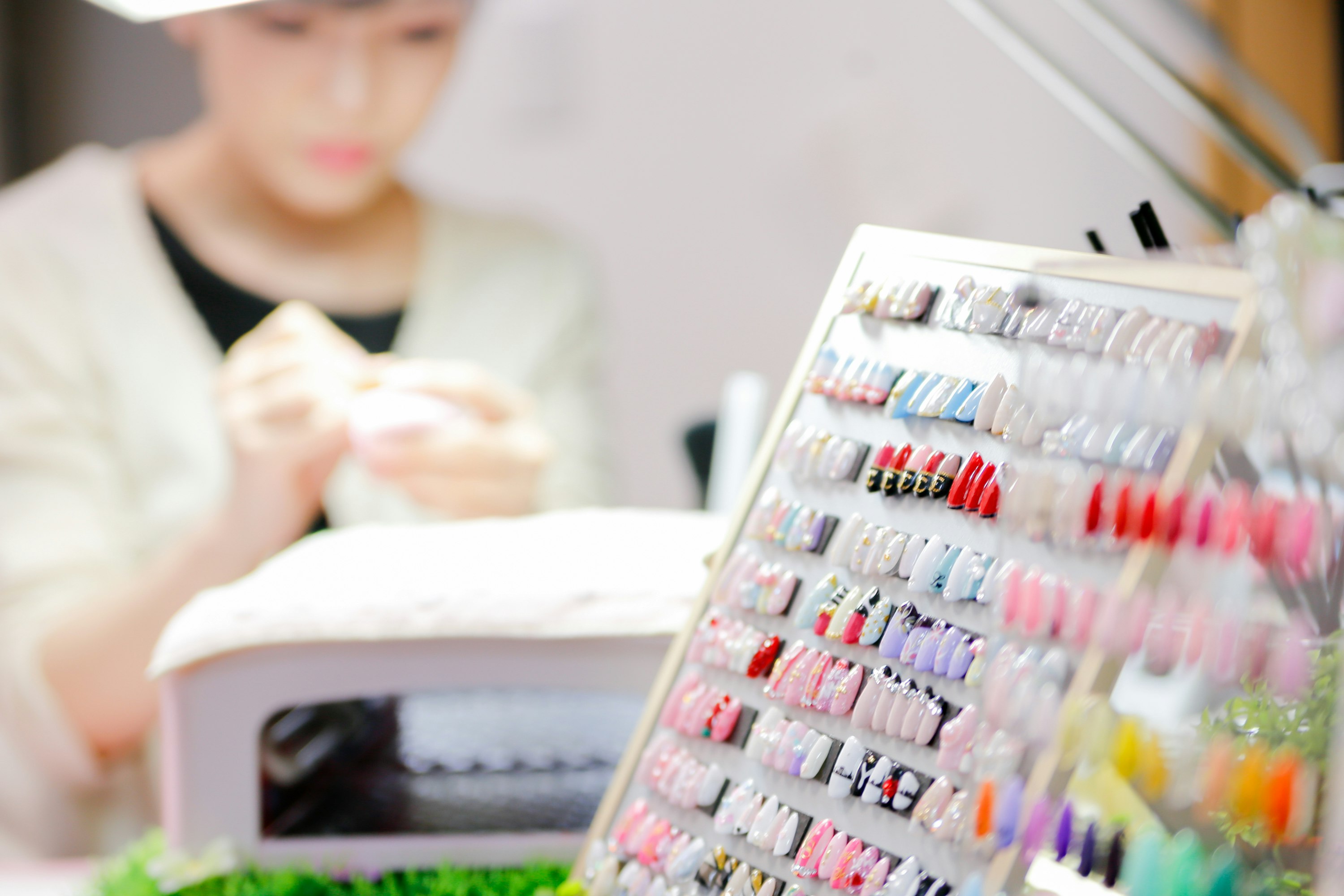 ネイルサロンのカラーチップと施術中の手元