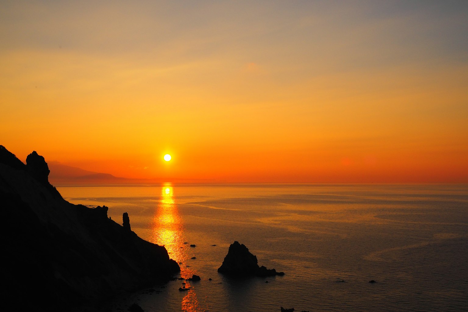 Beautiful landscape of sunset over the ocean with rocky coastline