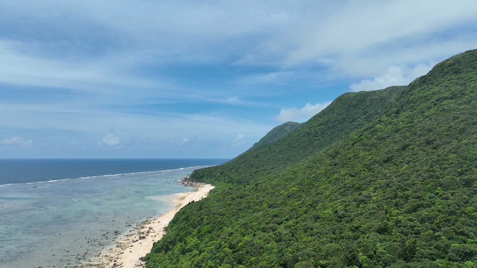 Schöne Küste umgeben von blauem Meer und grünen Bergen
