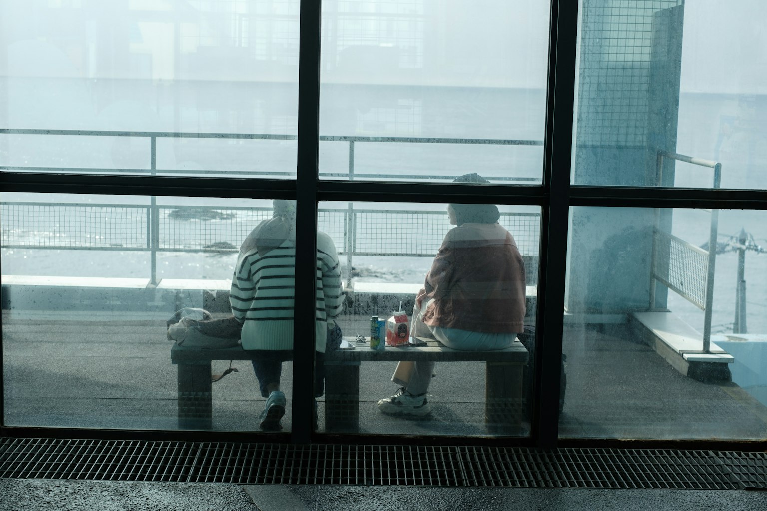 兩位女性在霧霾中坐在窗邊