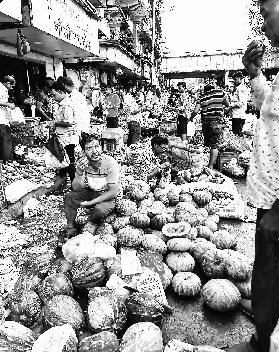 ムンバイの市場で並ぶ野菜や果物の屋台の通路
