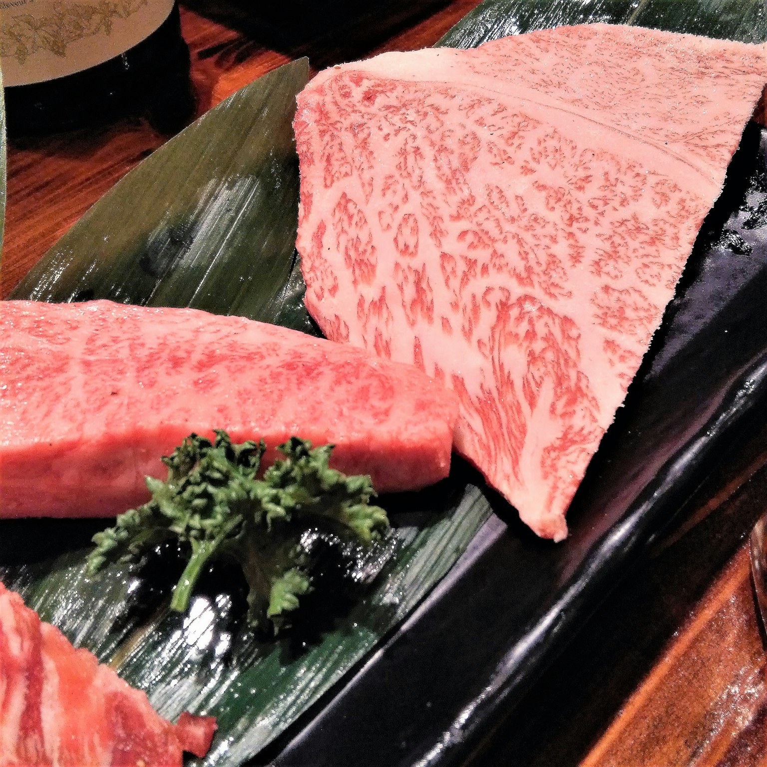 Eine schöne Anordnung von Wagyu-Rindfleisch auf einem schwarzen Teller