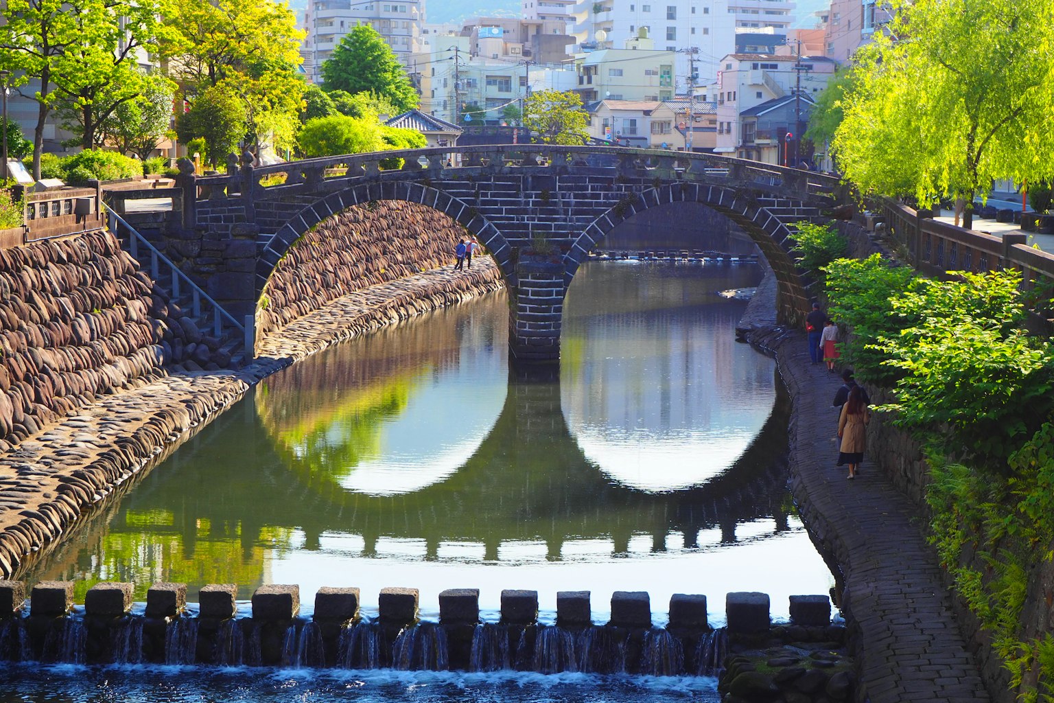 ทิวทัศน์สวยงามของสะพานโค้งสะท้อนในน้ำสงบ