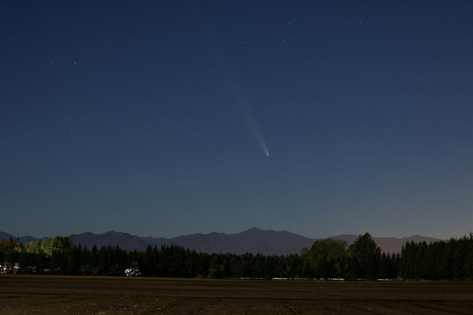 夜空中閃爍的彗星與山脈景觀