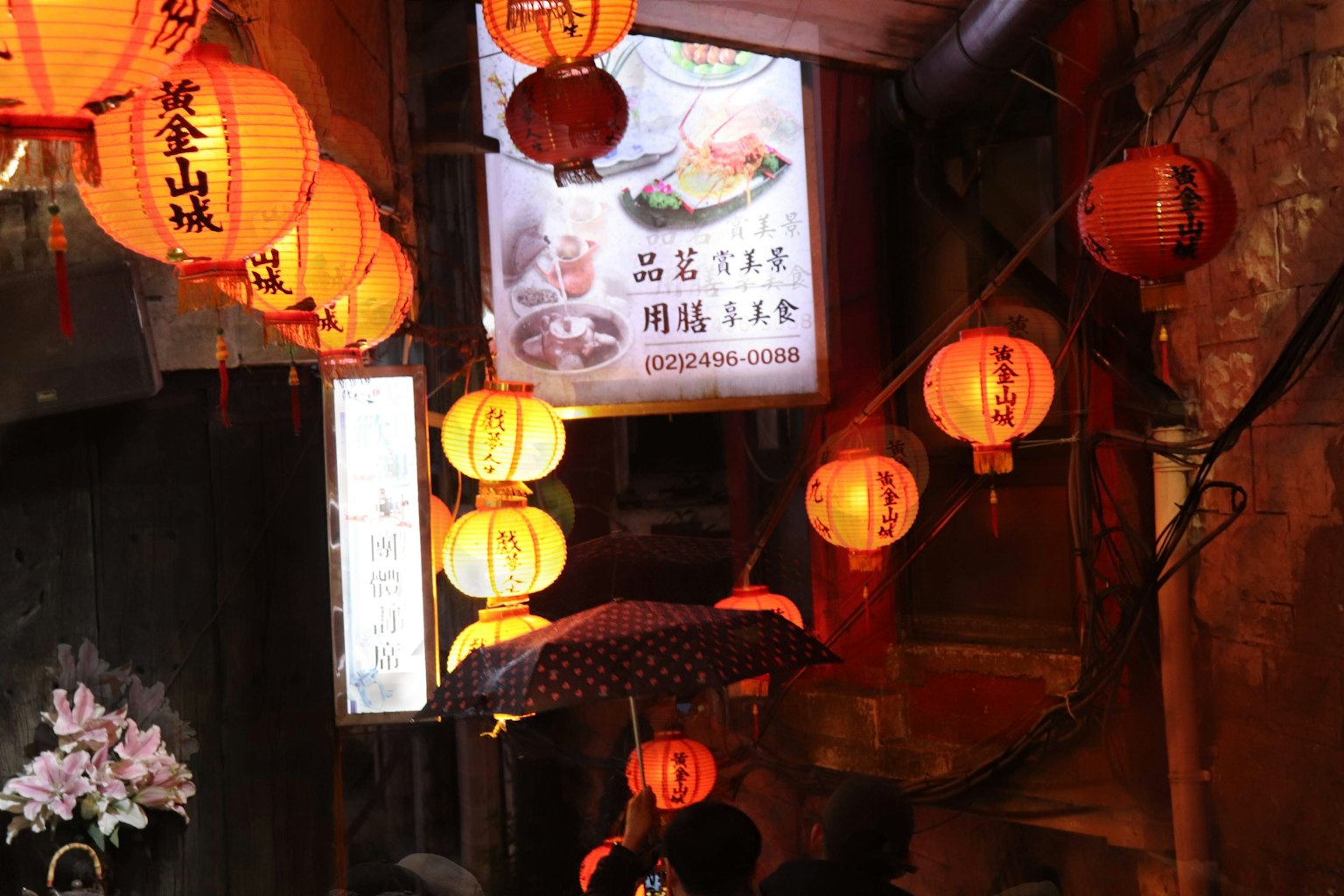 狹窄街道場景，紅色燈籠和商店招牌可見