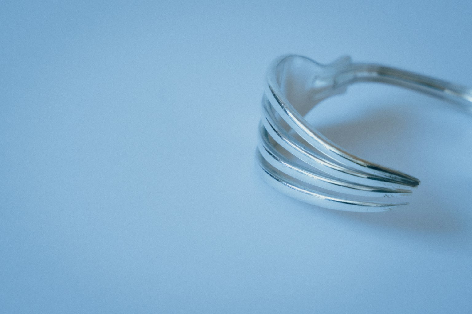Bracelet en argent élégant avec des lignes épurées sur fond bleu clair