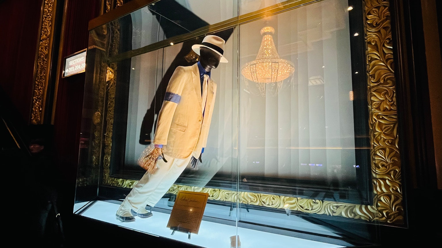玻璃展示櫃中展示的白色西裝和帽子