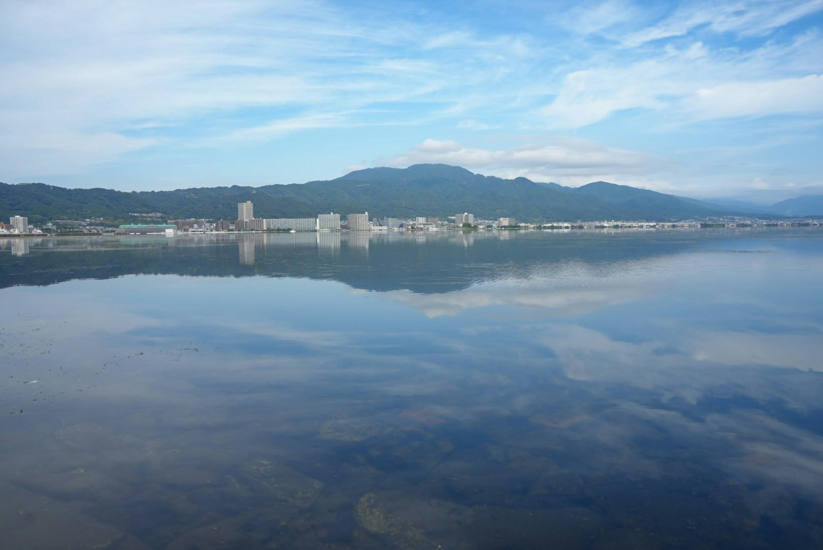 朝の琵琶湖の水面に映る空と山並み