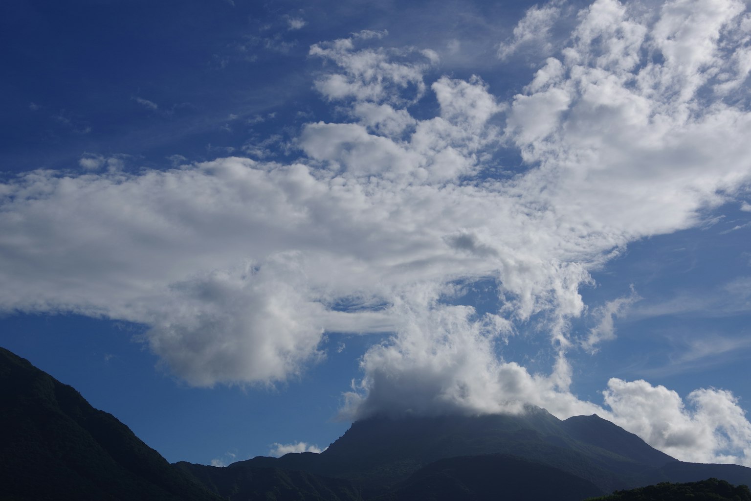 Pemandangan gunung dengan langit biru dan awan putih