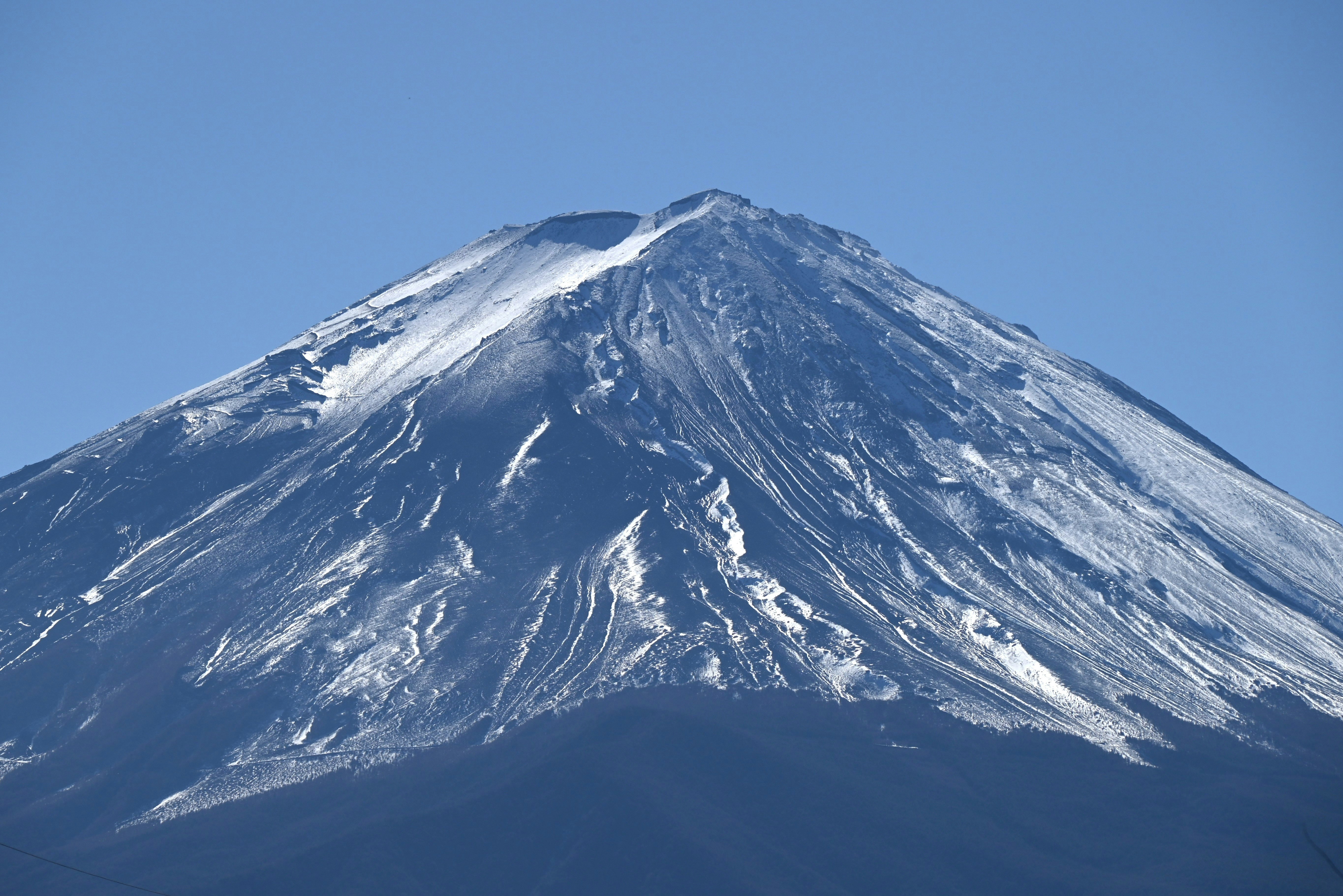 sommet de montagne enneigé sous un ciel bleu dégagé