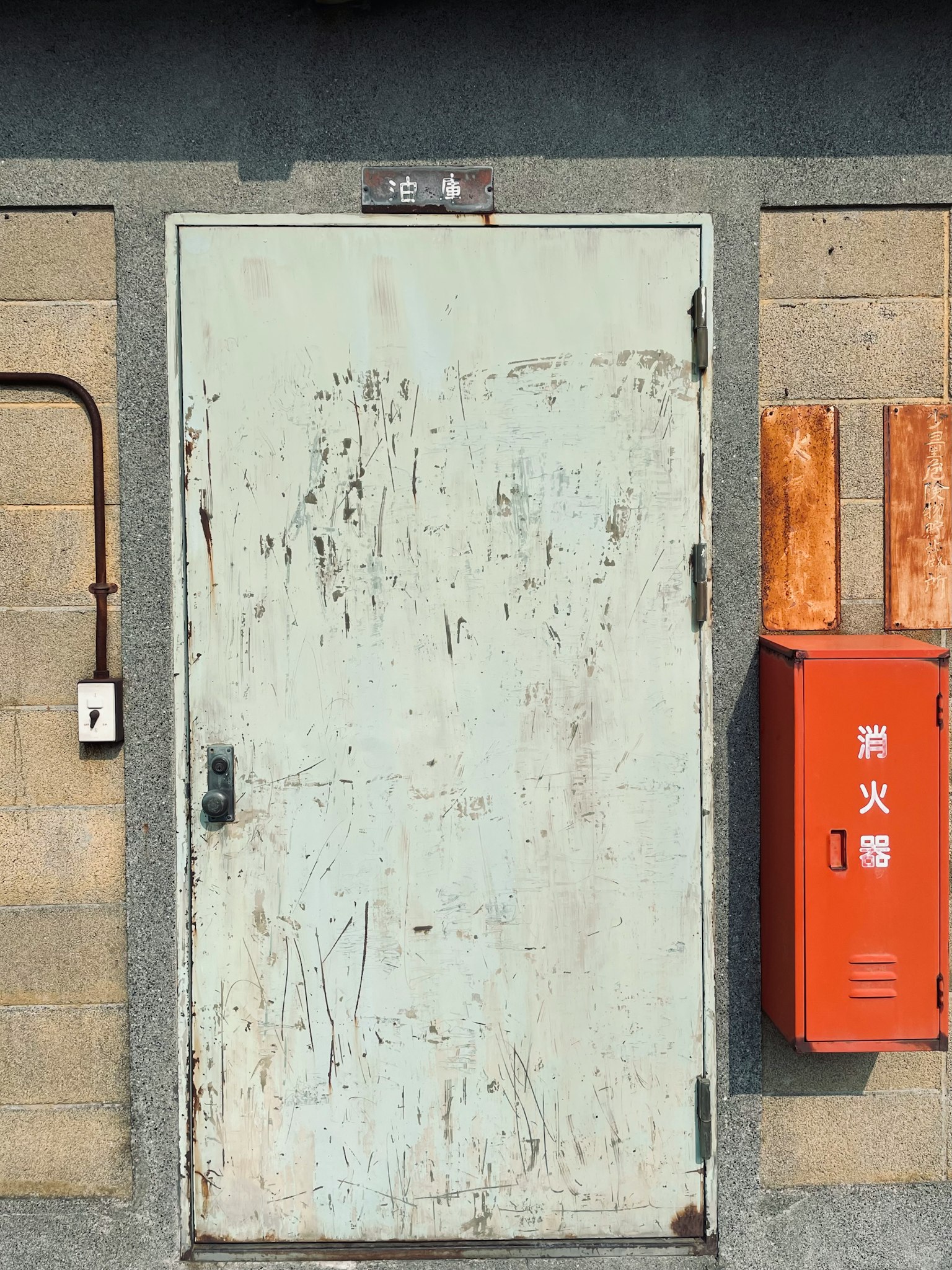 Porta verde vecchia con una cassetta postale rossa sul muro