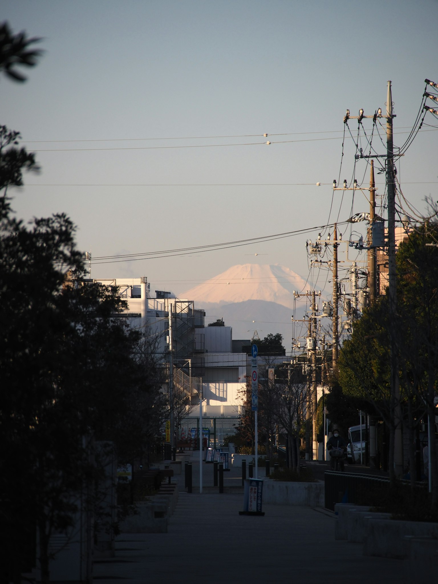 Street view featuring Mount Fuji in the distance with power lines