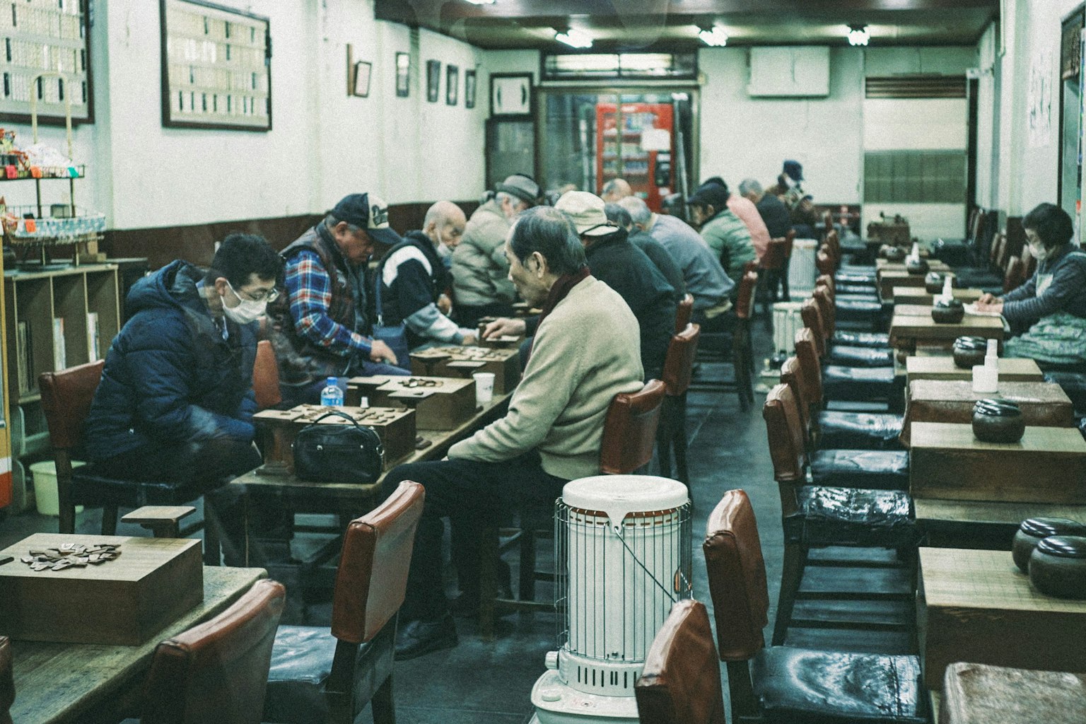 Nội thất của một quán cà phê cũ với nhiều người đàn ông đang thưởng thức trò chơi trên bàn