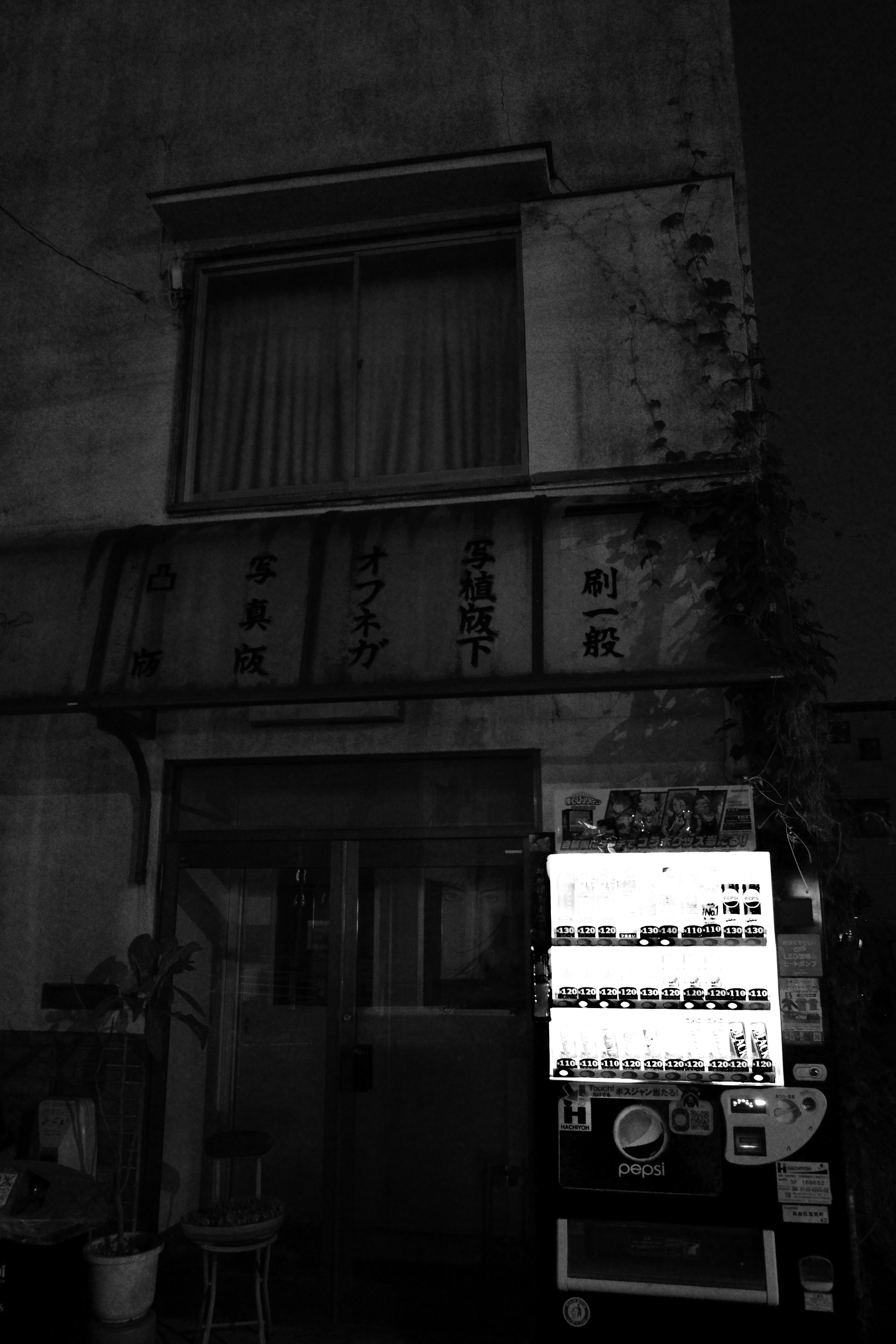 提灯と看板が並ぶ夜の路地の店先