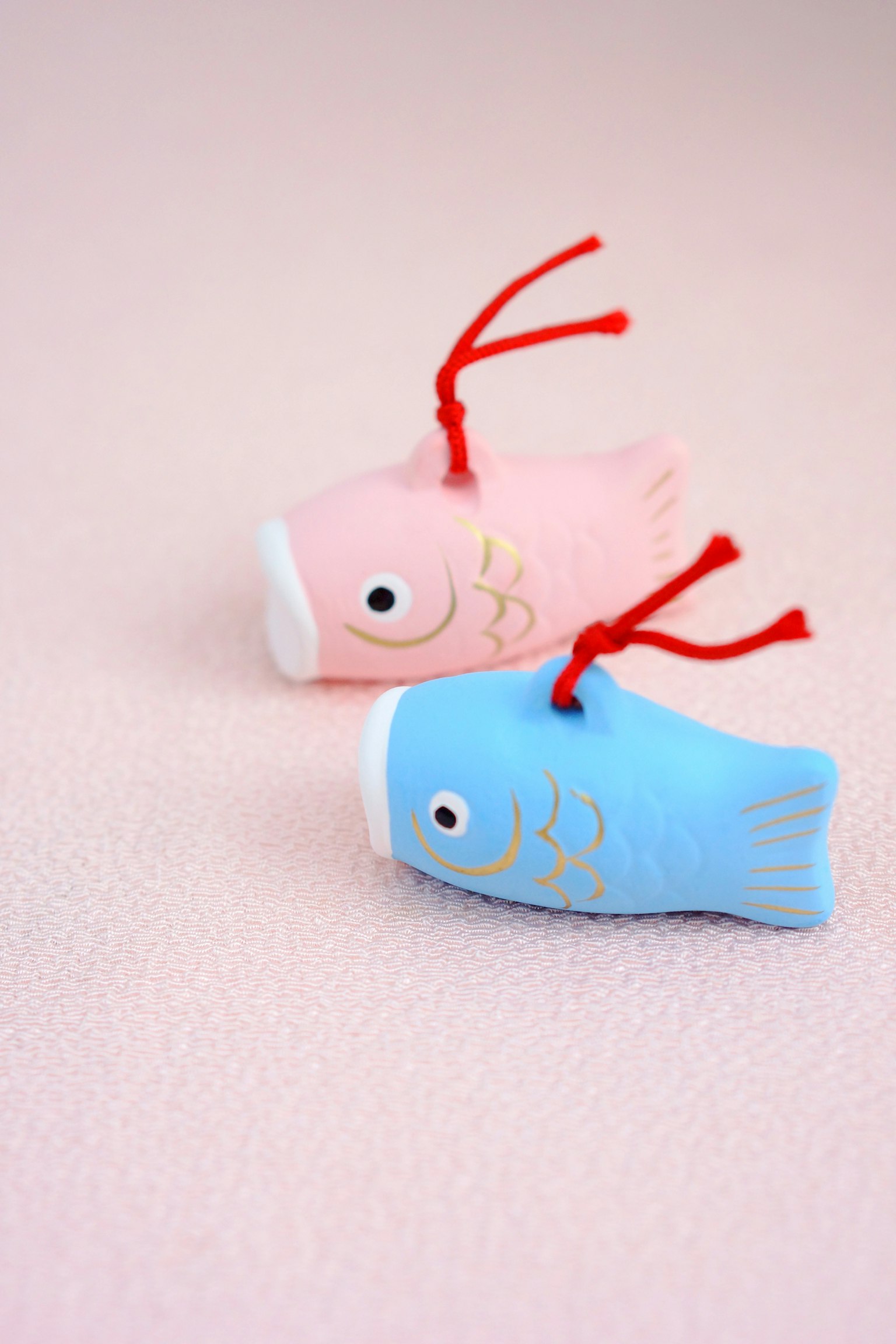 Dua mainan berbentuk ikan berwarna pink dan biru diletakkan berdampingan