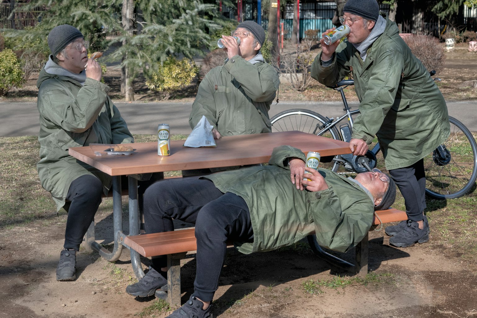 公園のテーブルで飲み物を楽しむ人々のグループ