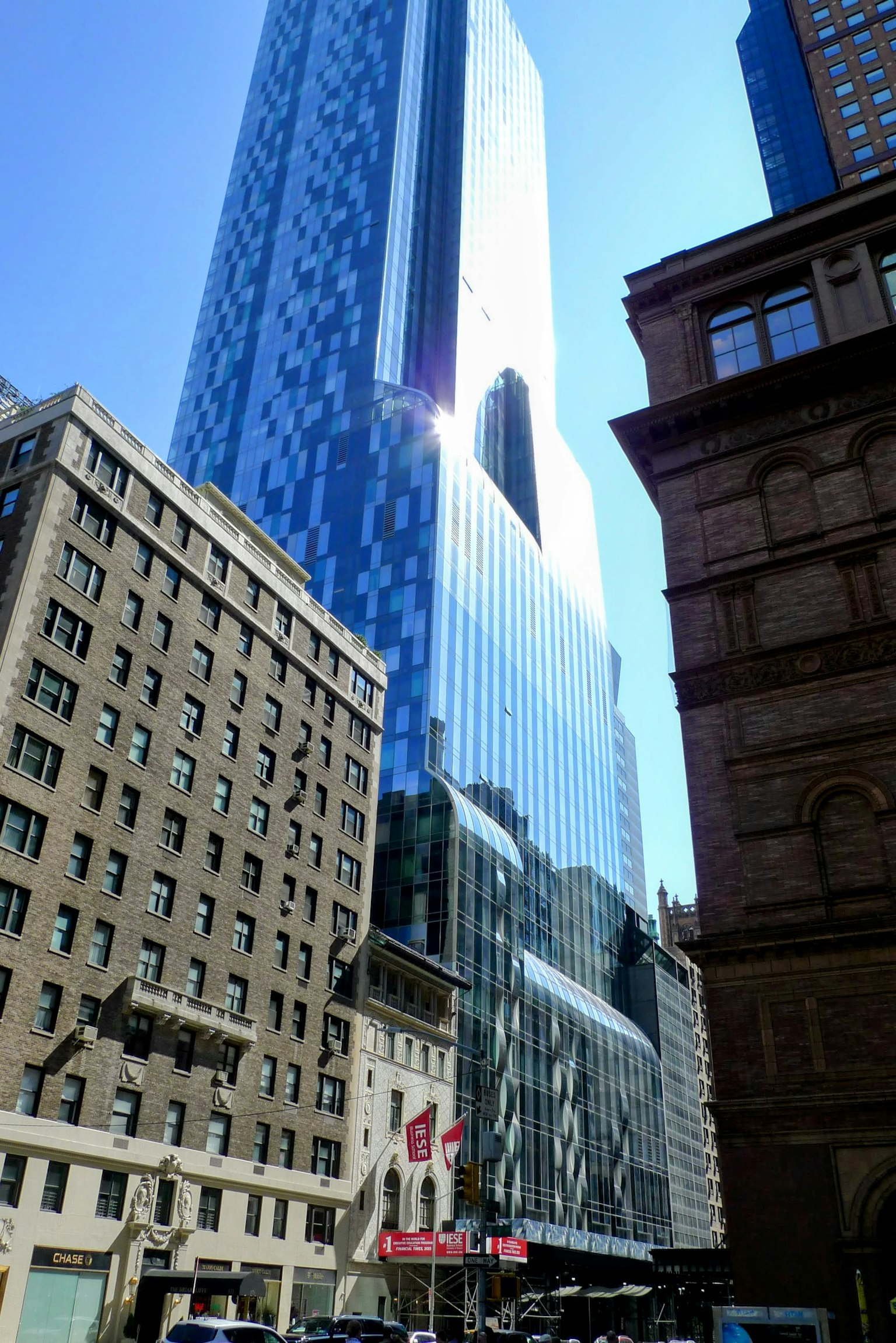 Rascacielos moderno reflejando la luz del sol en un entorno urbano