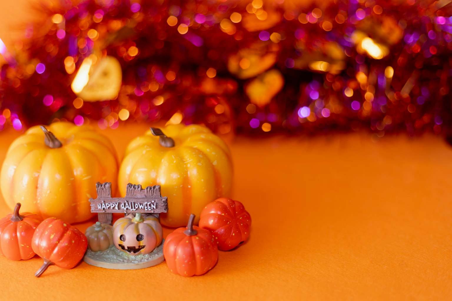 Zucche colorate e decorazioni di Halloween su uno sfondo arancione