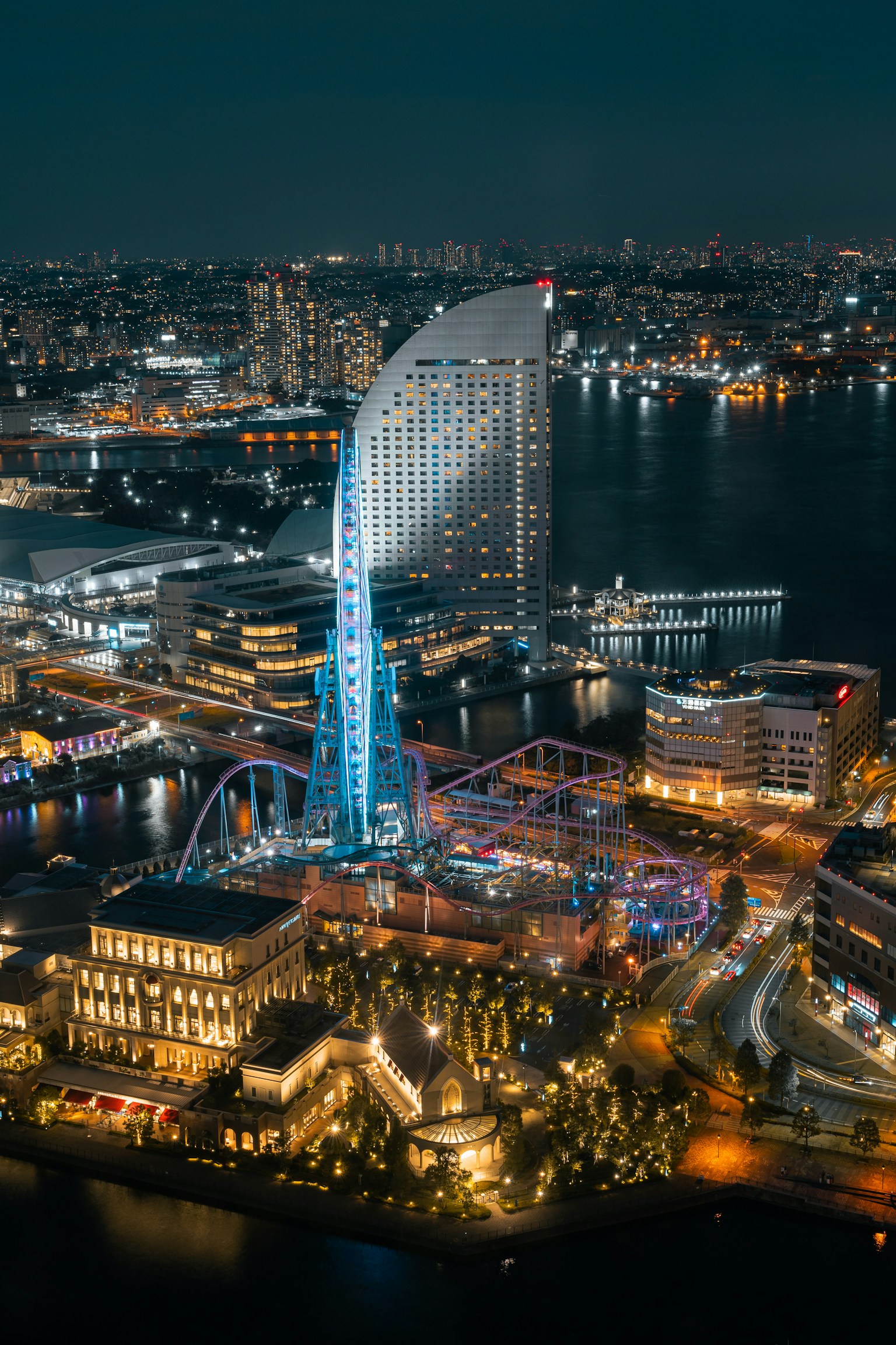 Impressionante vista notturna di Yokohama con un grattacielo iconico e attrazioni illuminate