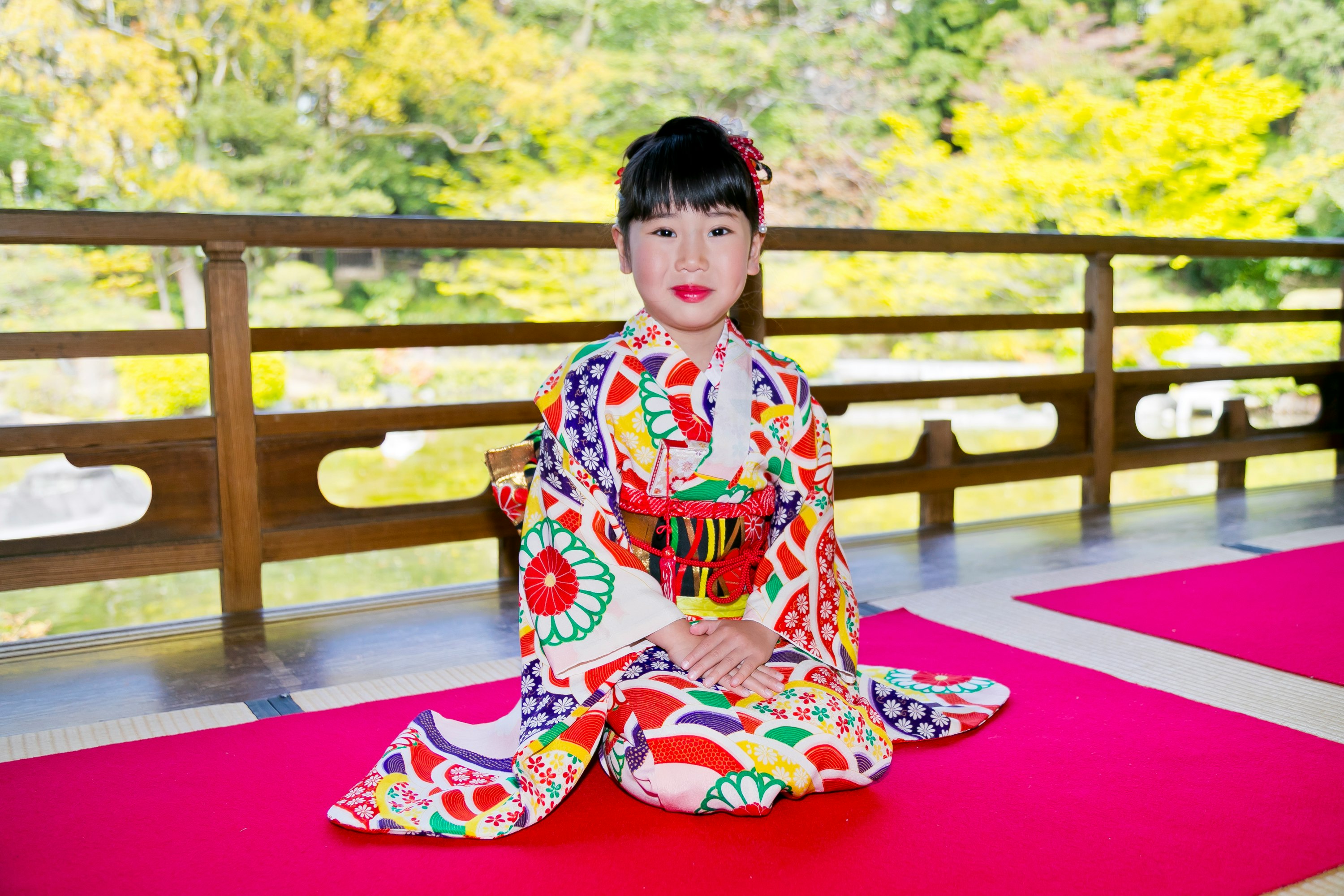 庭園のベンチで座る着物姿の子ども