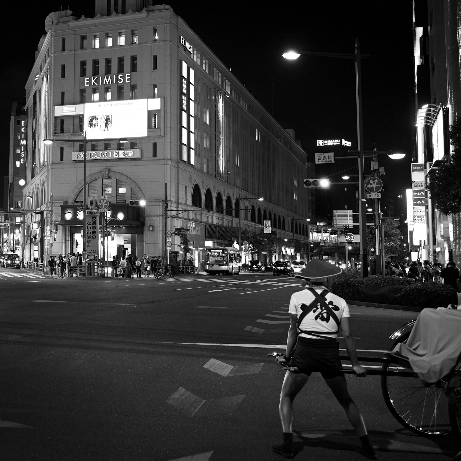 夜晚在街角持自行车的人与EKIMISE建筑