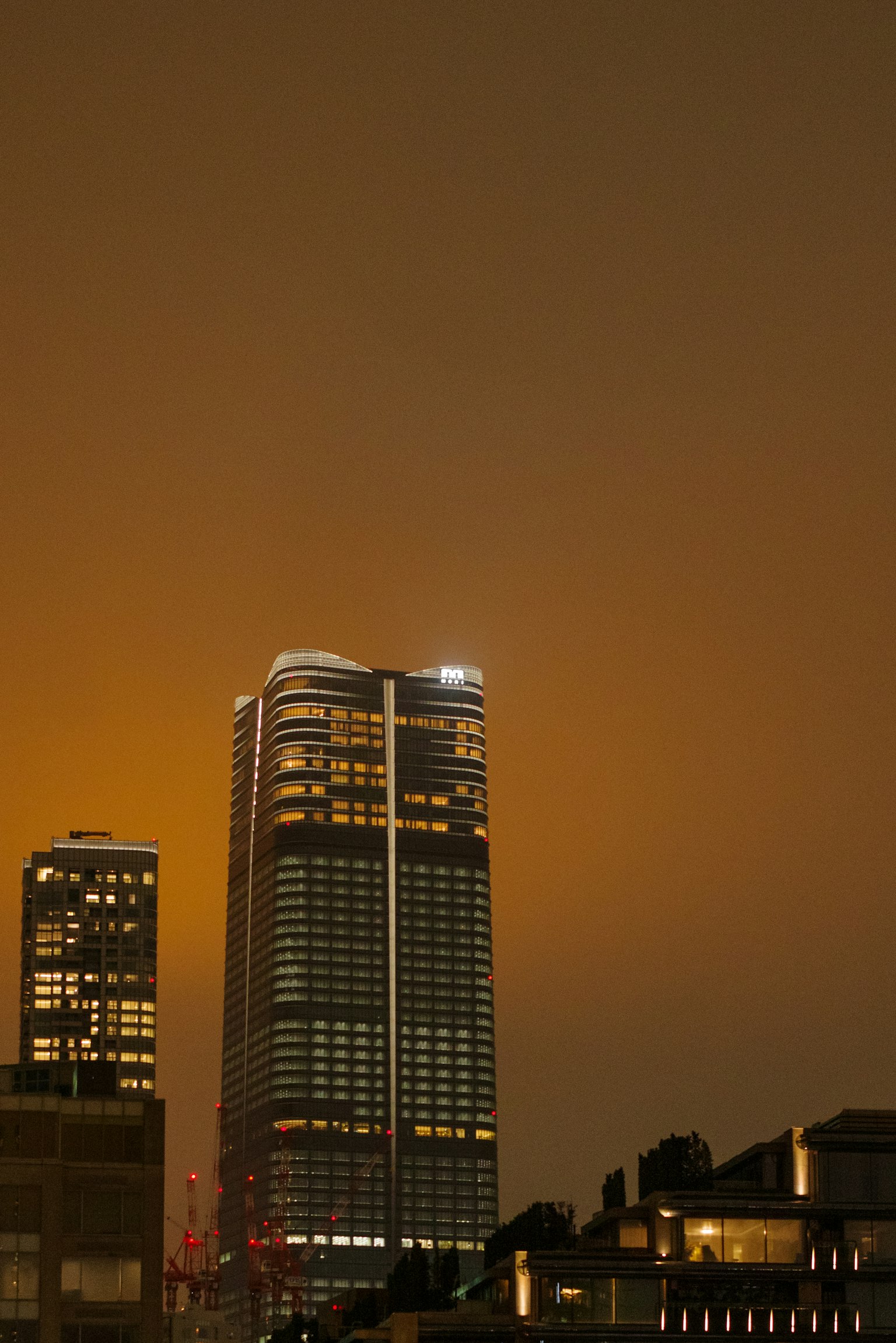 Teil einer Skyline mit beleuchteten Wolkenkratzern bei Nacht in Tokio