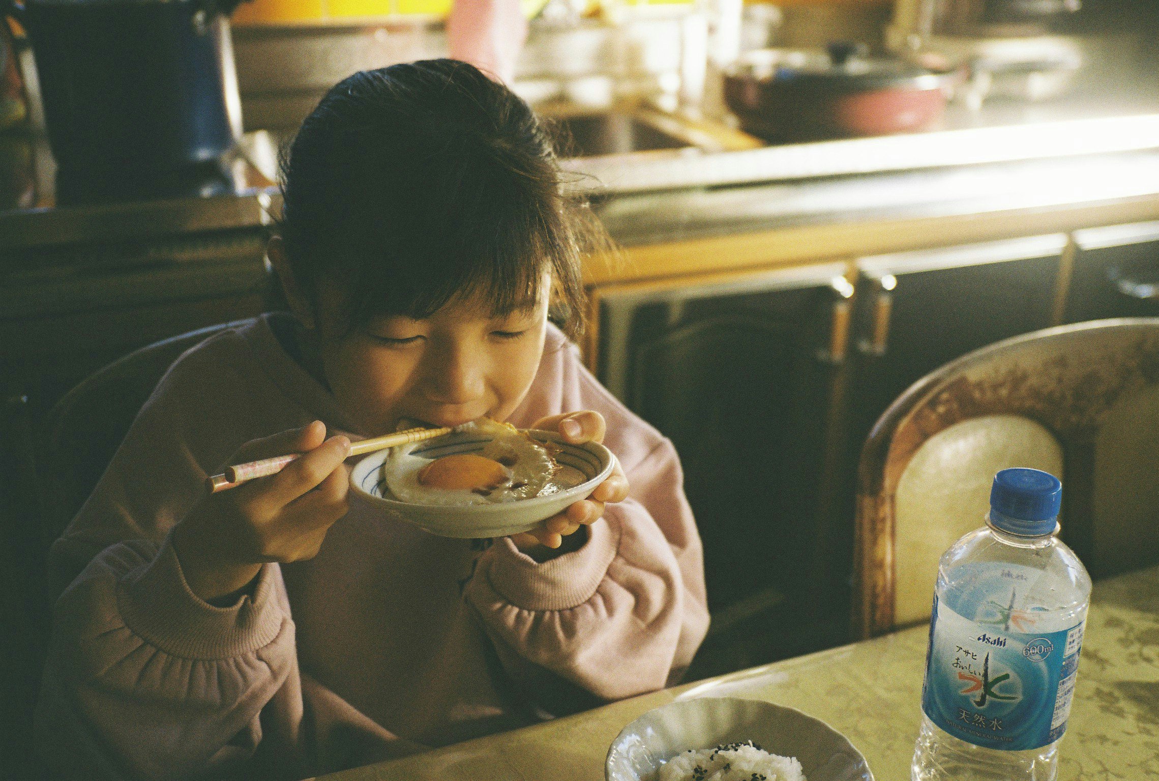 食卓でスープを食べる子ども