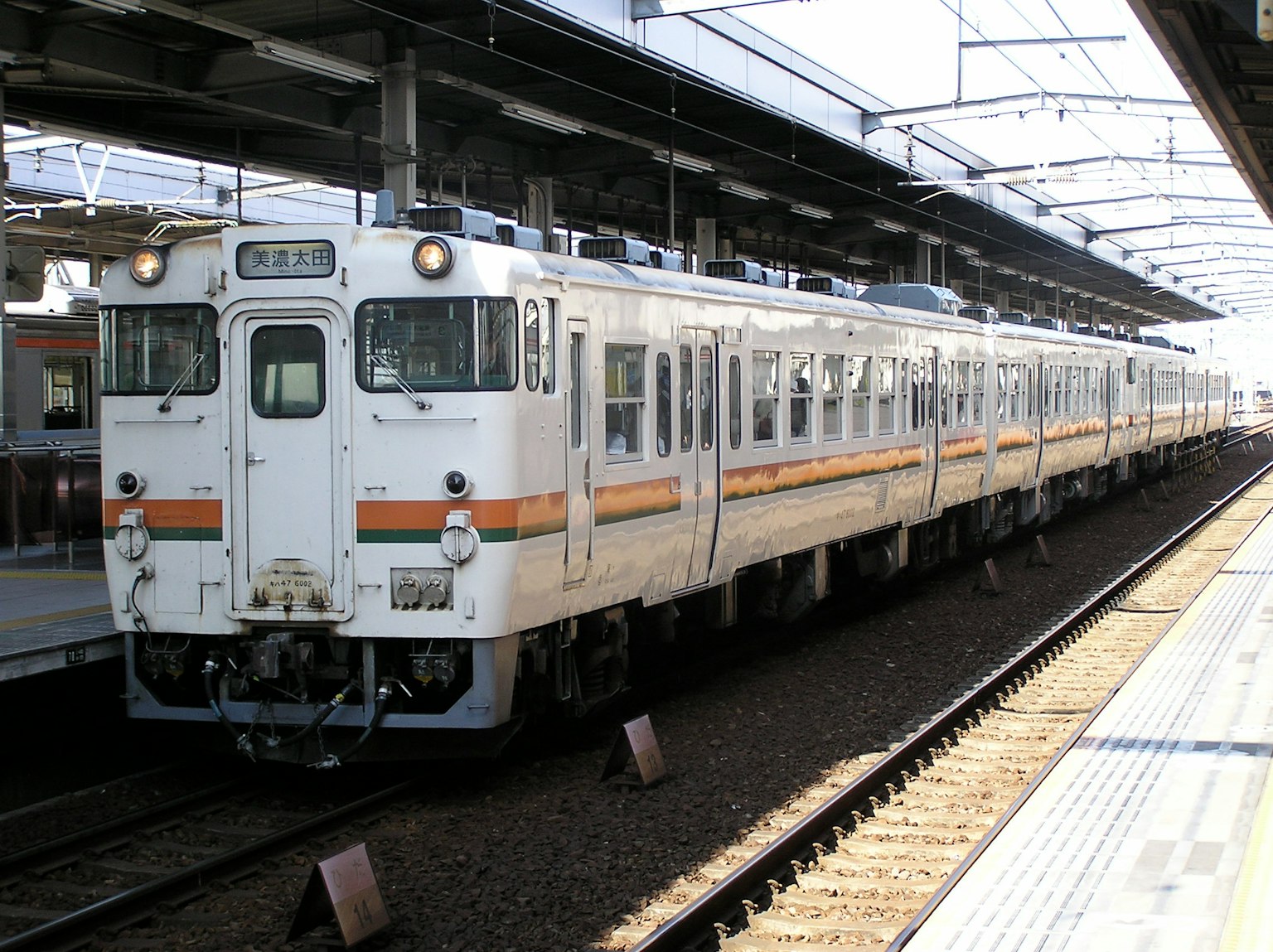 Un train blanc est garé à une station