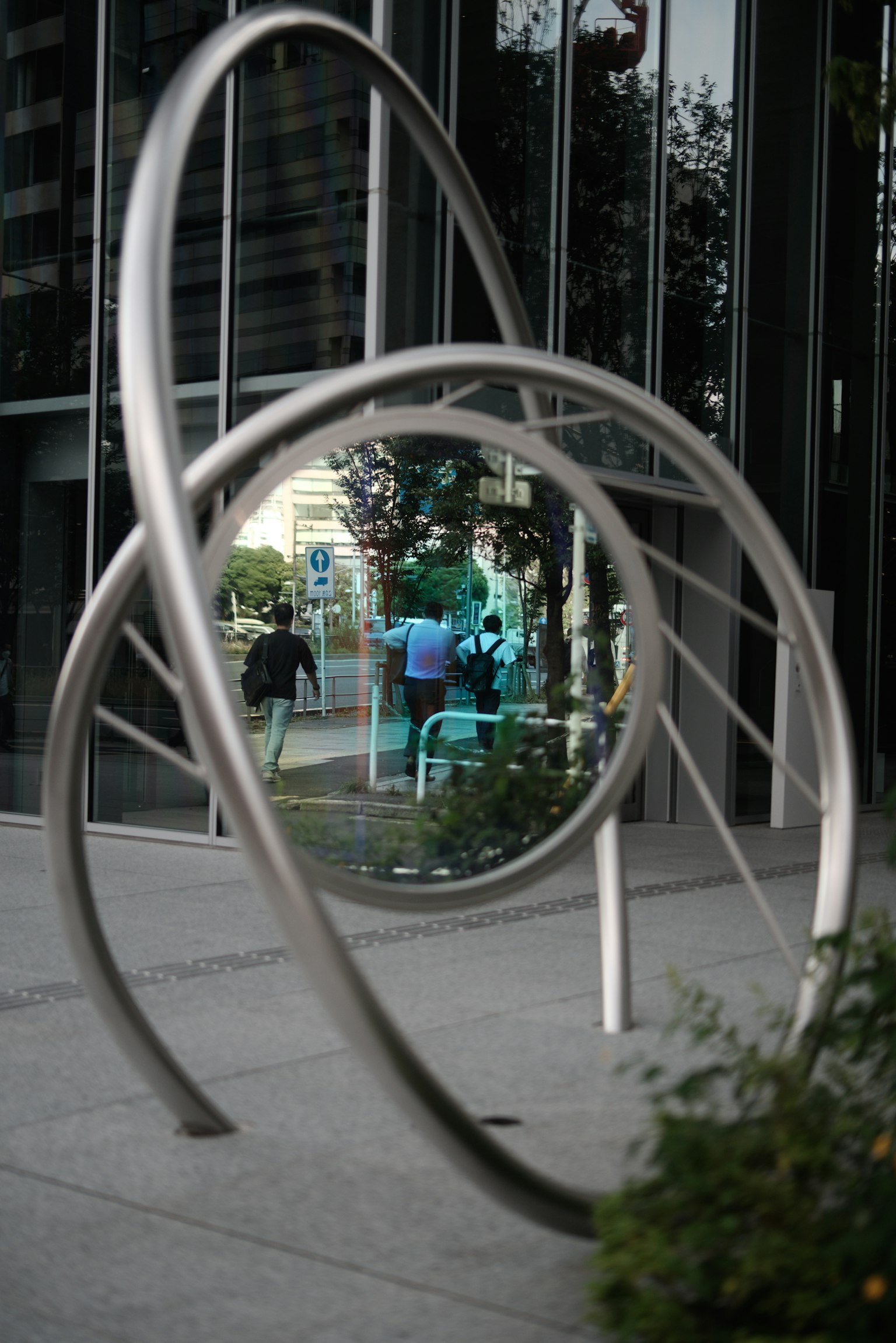 Metallkunstskulptur, die die Landschaft und Menschen reflektiert