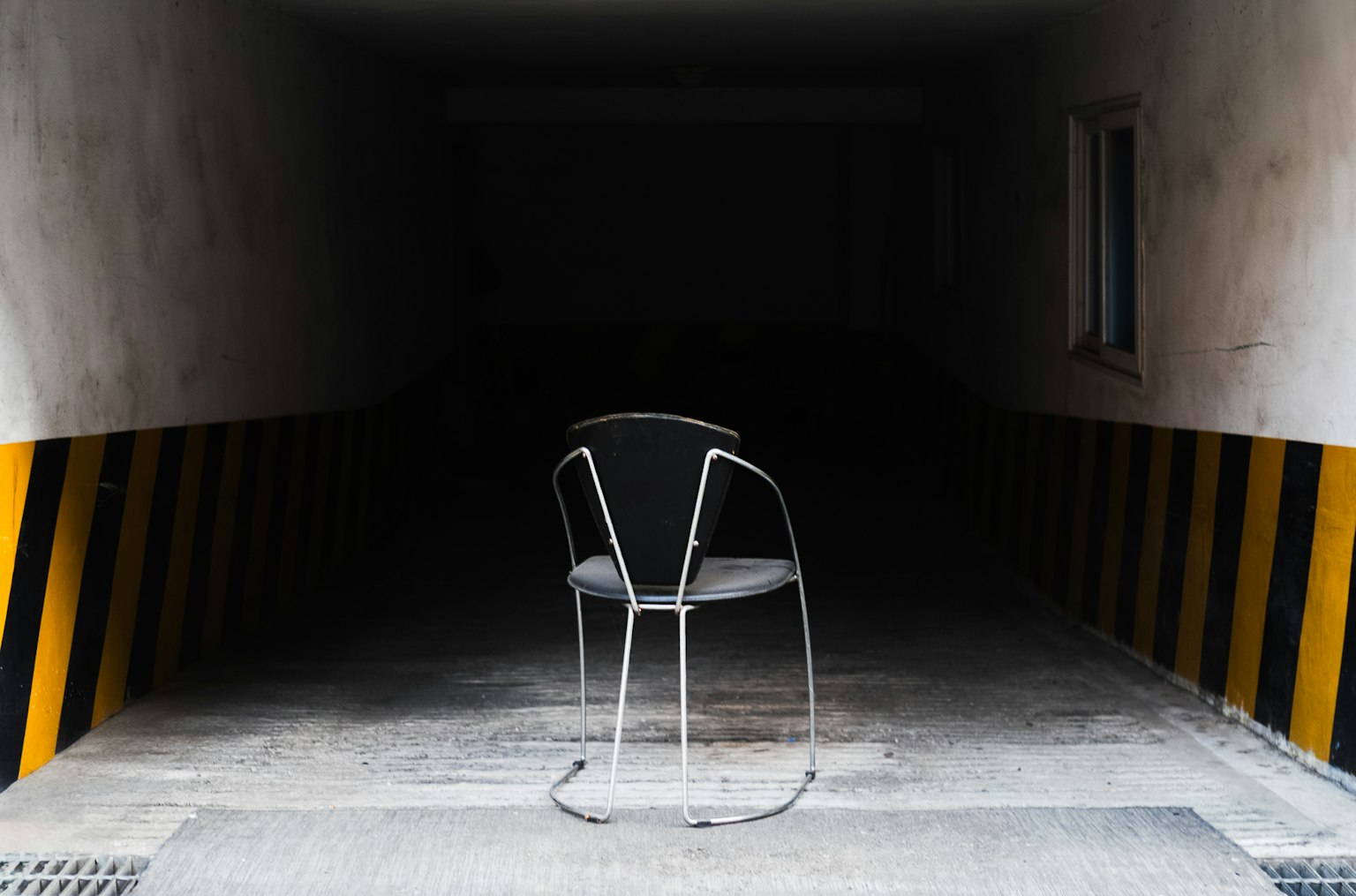 暗いトンネルの中に置かれた金属製の椅子