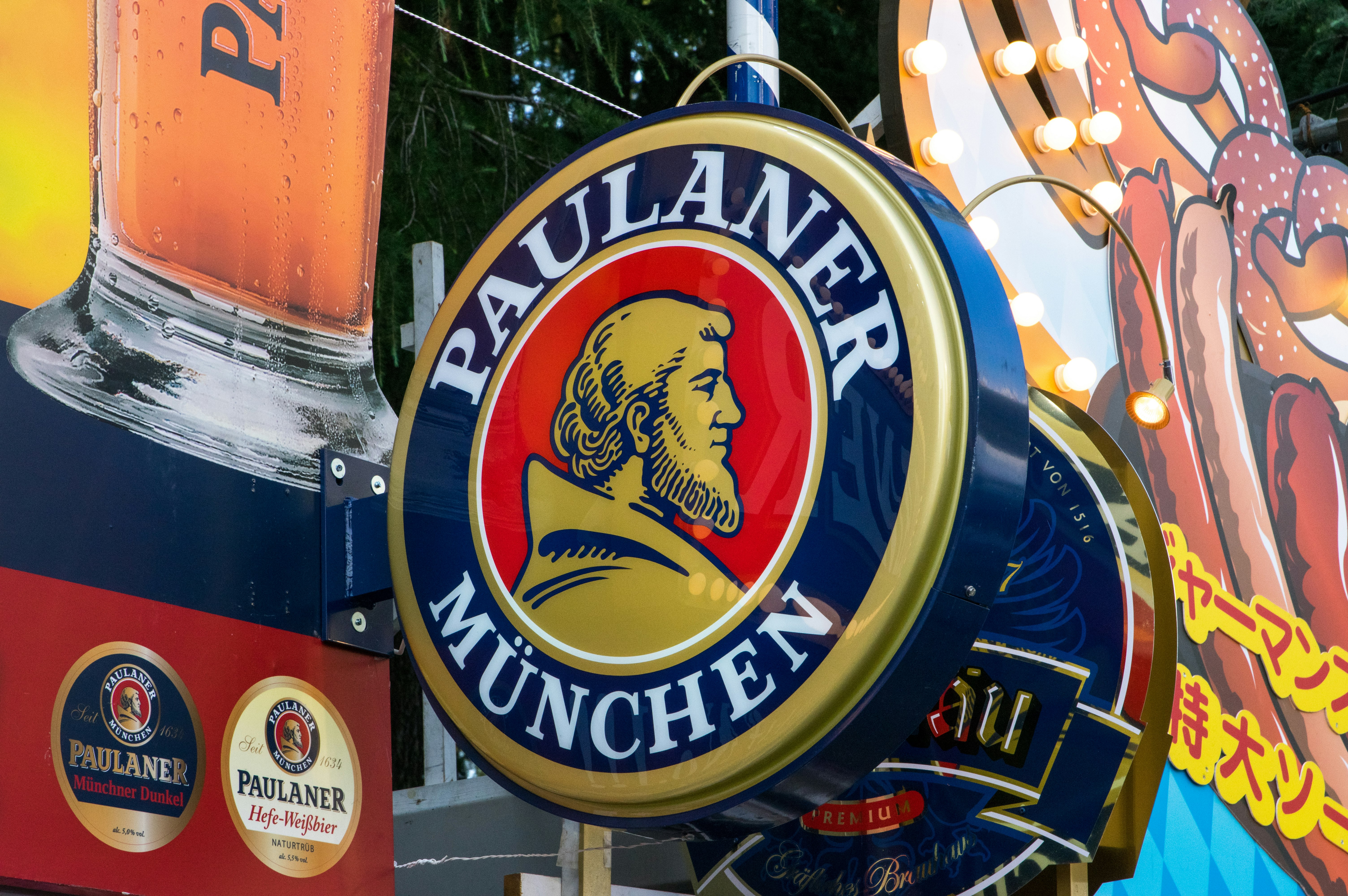 Paulaner logo sign and beer barrels at a storefront