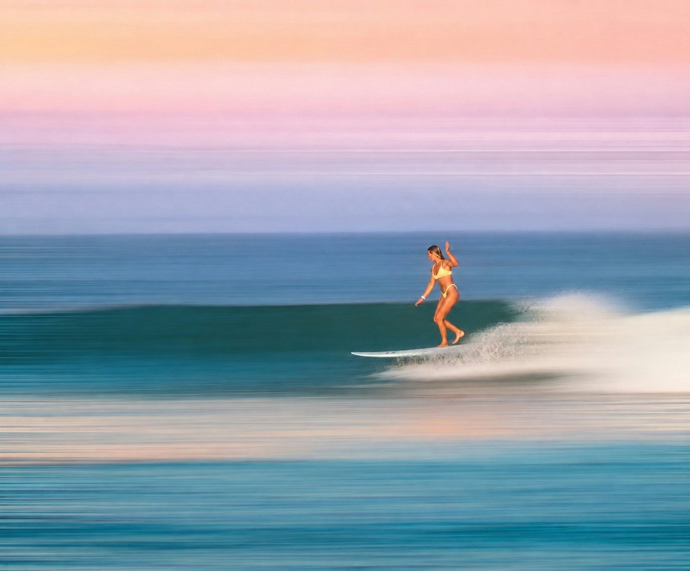A surfer girl running along the Malibu shoreline