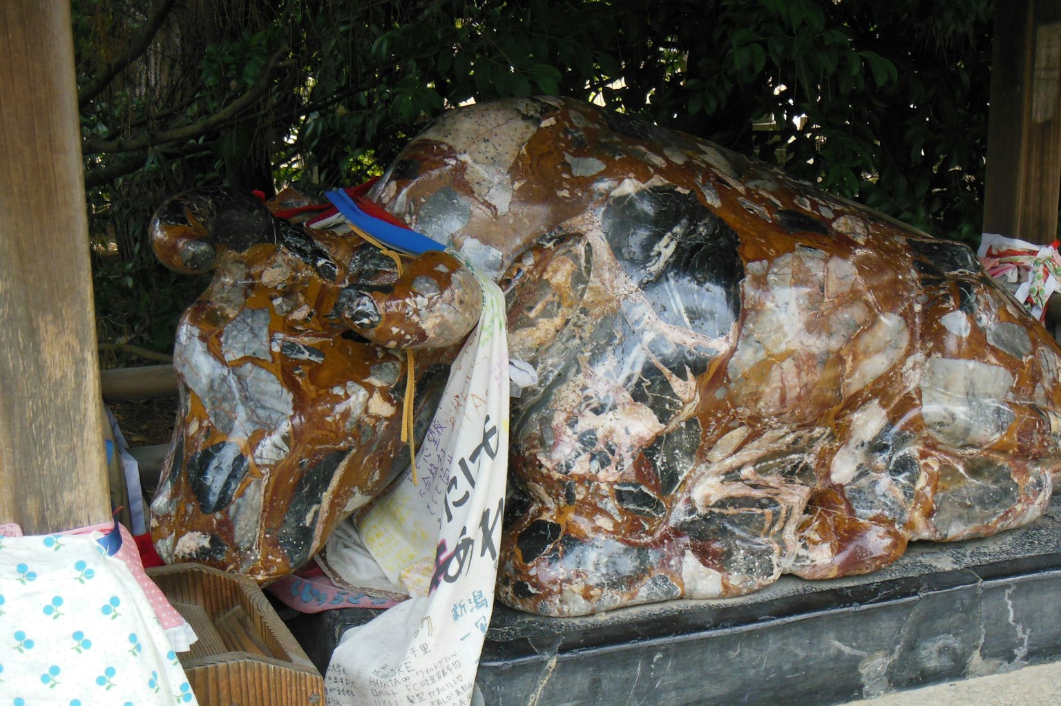 Una grande statua di mucca marrone avvolta in plastica trasparente