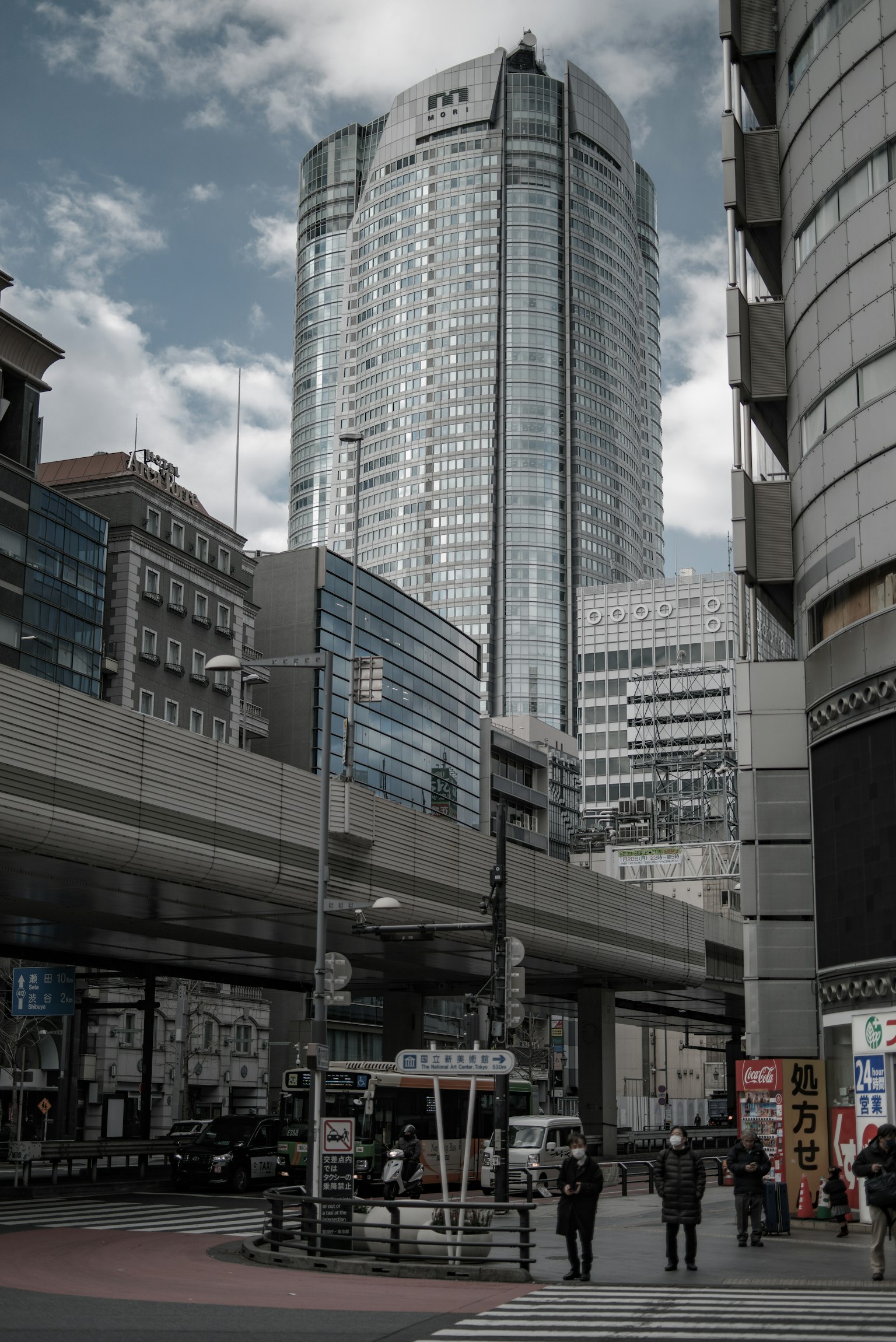 城市景觀，背景為高樓和在十字路口行走的行人