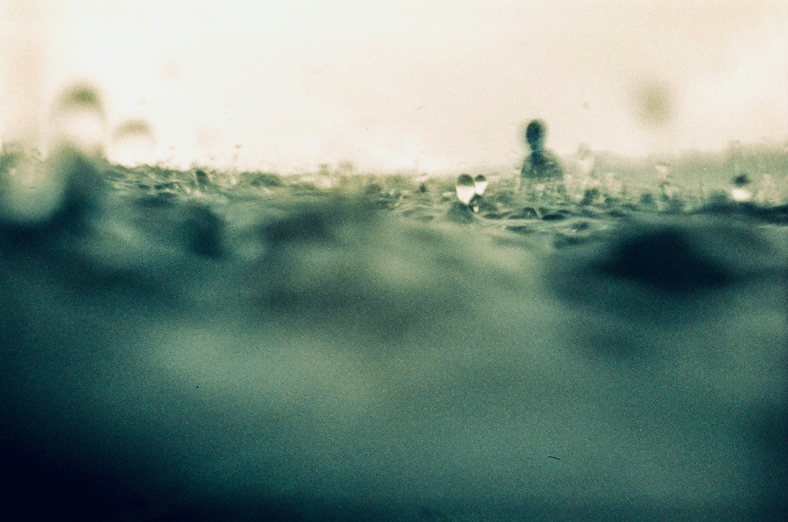 雨の中を歩く人々のある霧のような水辺の風景
