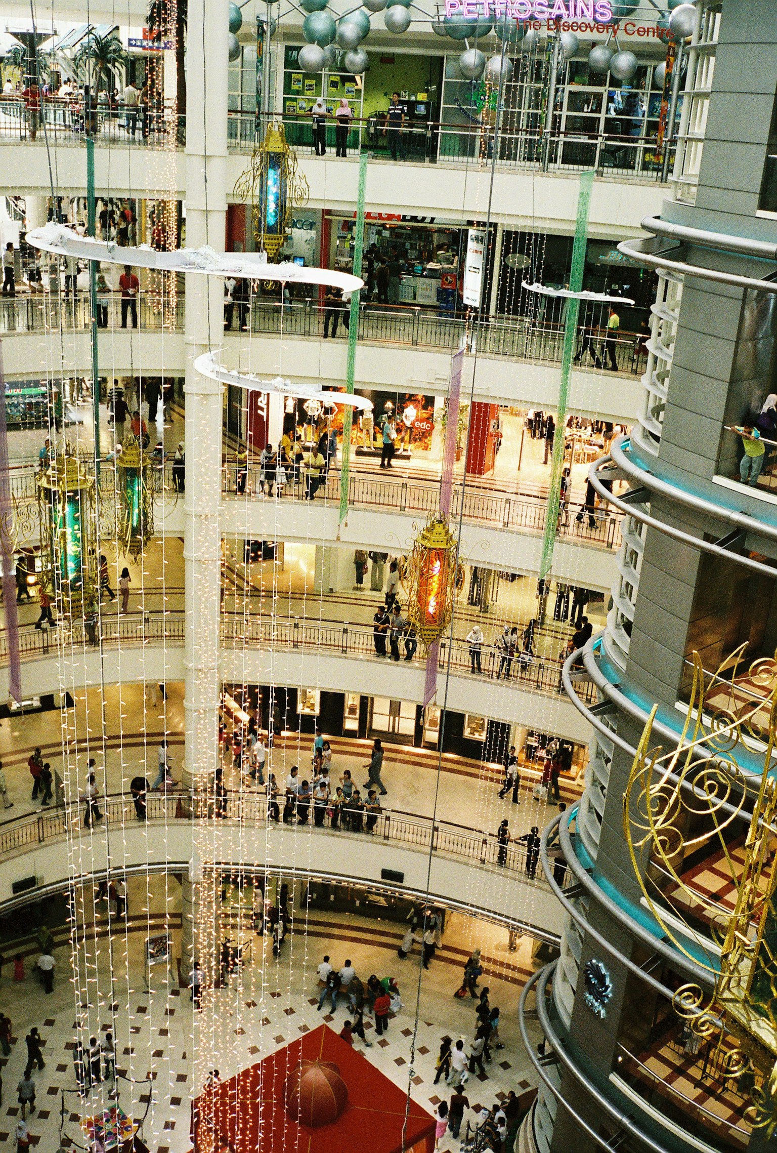 Vista aerea di un ampio centro commerciale con più piani e numerosi acquirenti