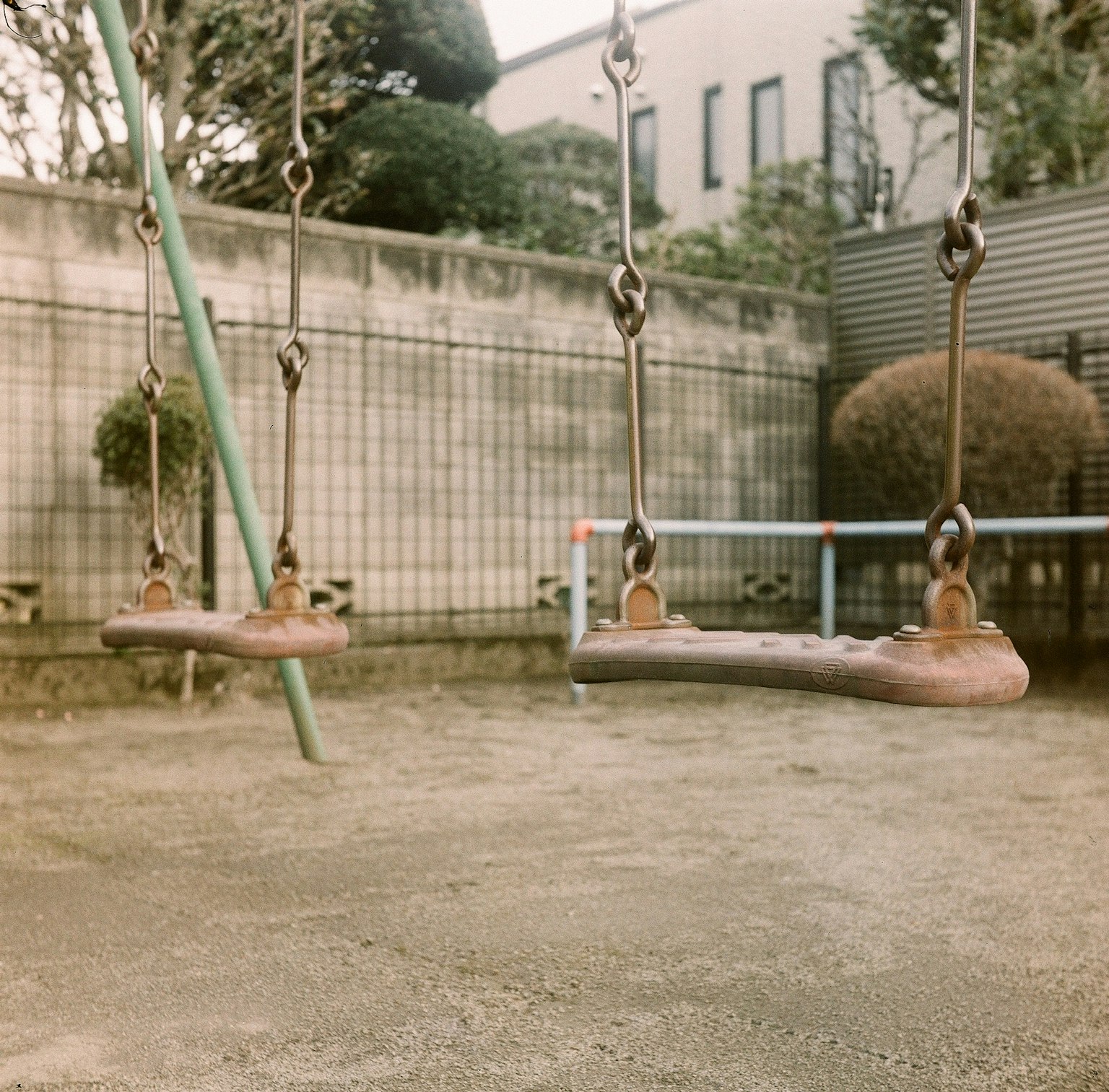 Two swings in a playground with a blurred background