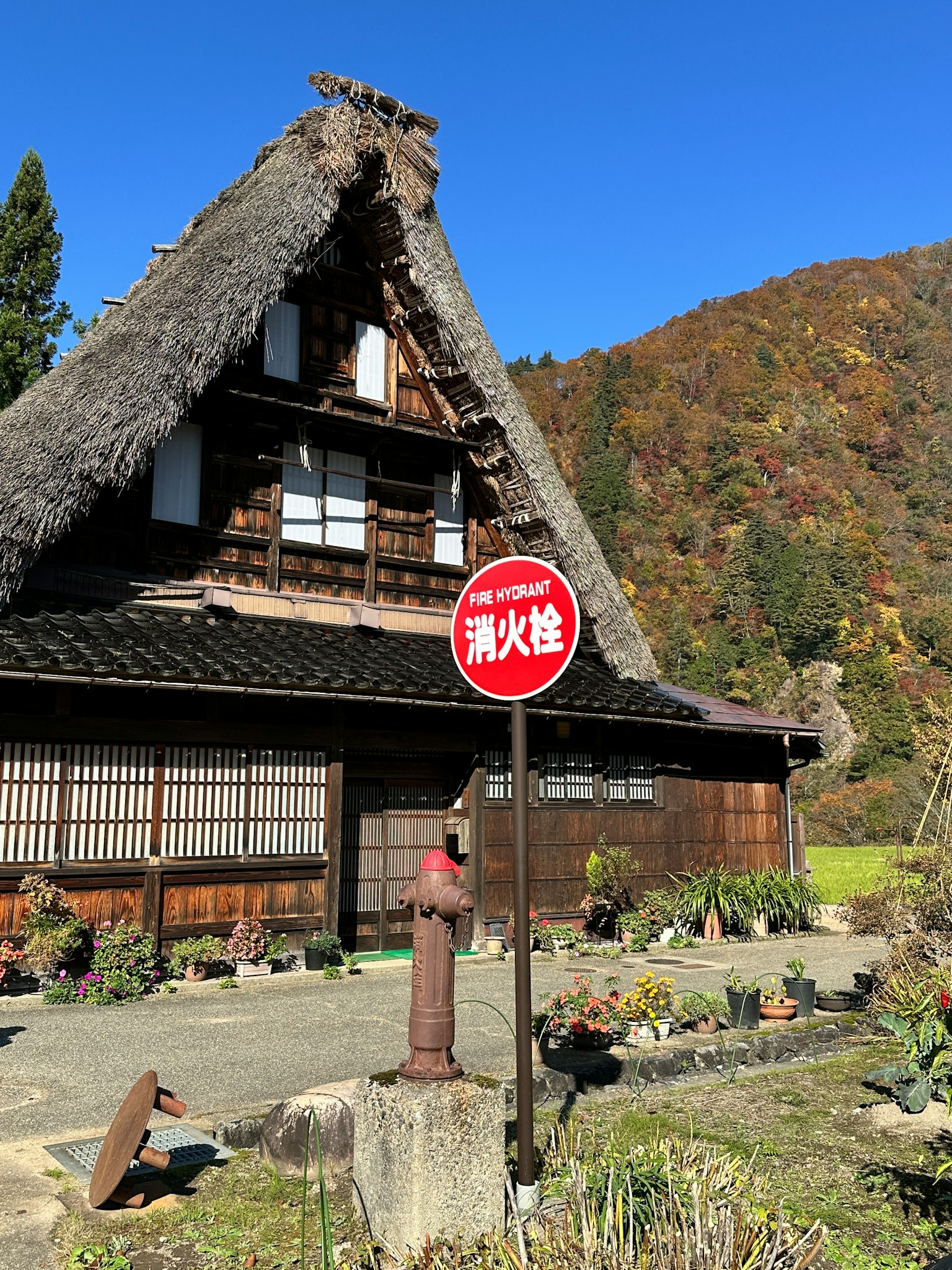 传统茅草屋顶房屋和前景中的红色标志